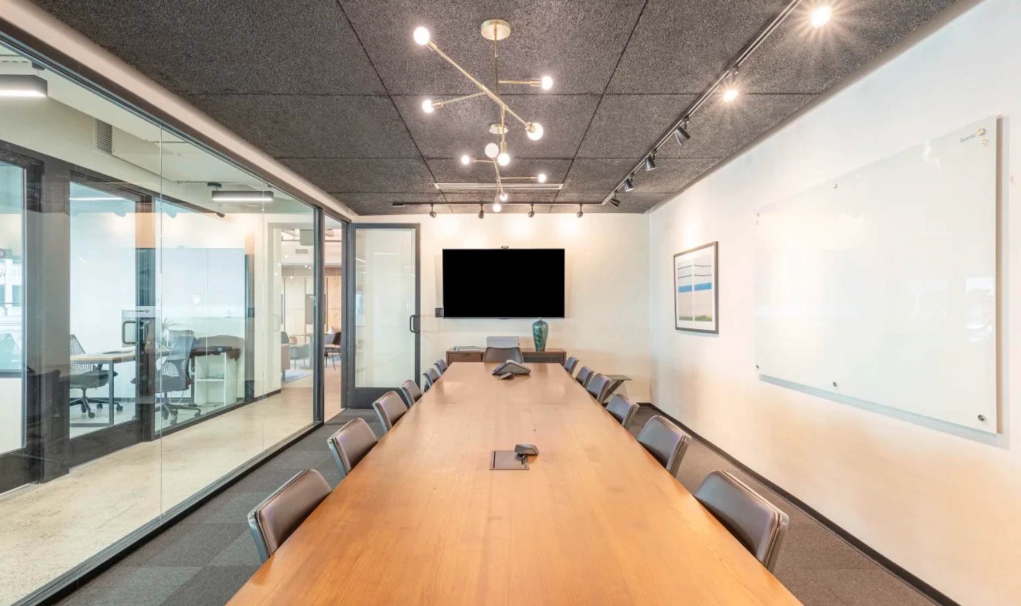 Une salle de conférence de coworking à Atlanta avec une longue table, des chaises et un environnement de bureau.