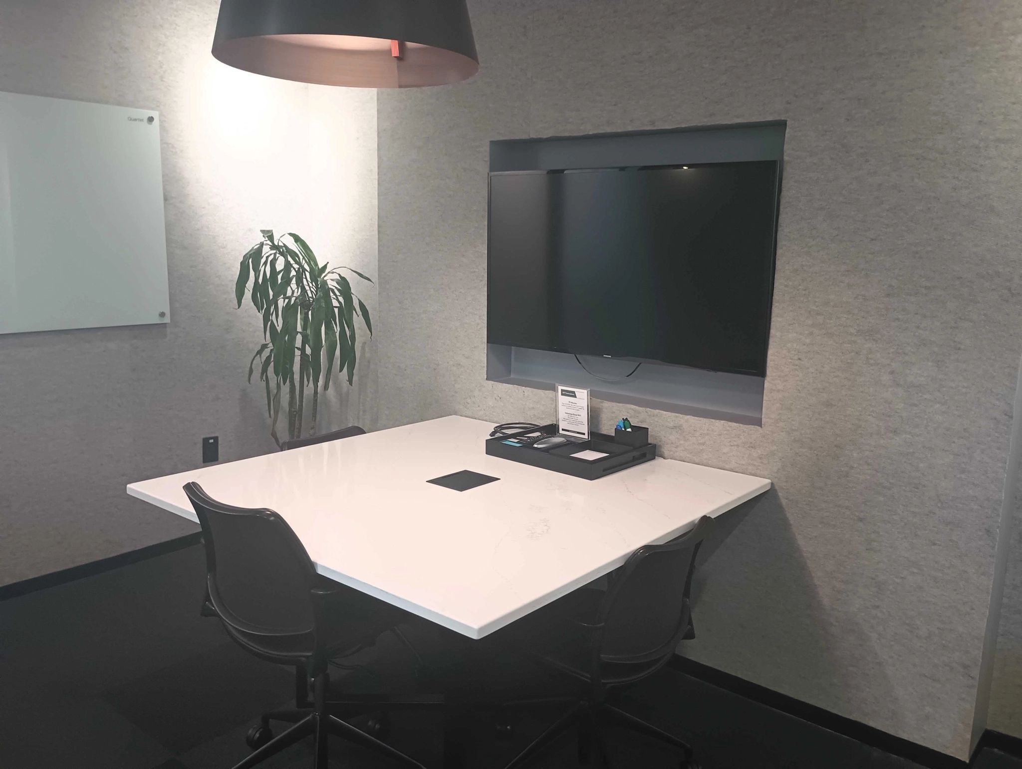 A coworking meeting room featuring a white table and chairs.