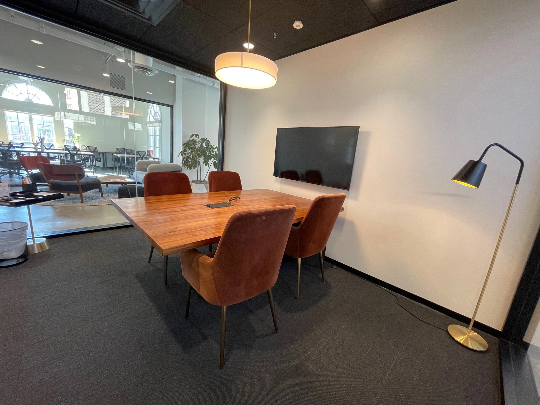 Een coworking-ruimte in Kansas City met een conferentieruimte met een houten tafel en stoelen.