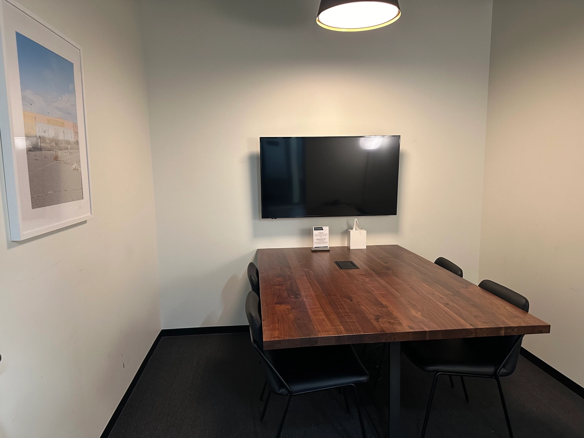 An office meeting room in Costa Mesa equipped with a table, chairs, and a TV.