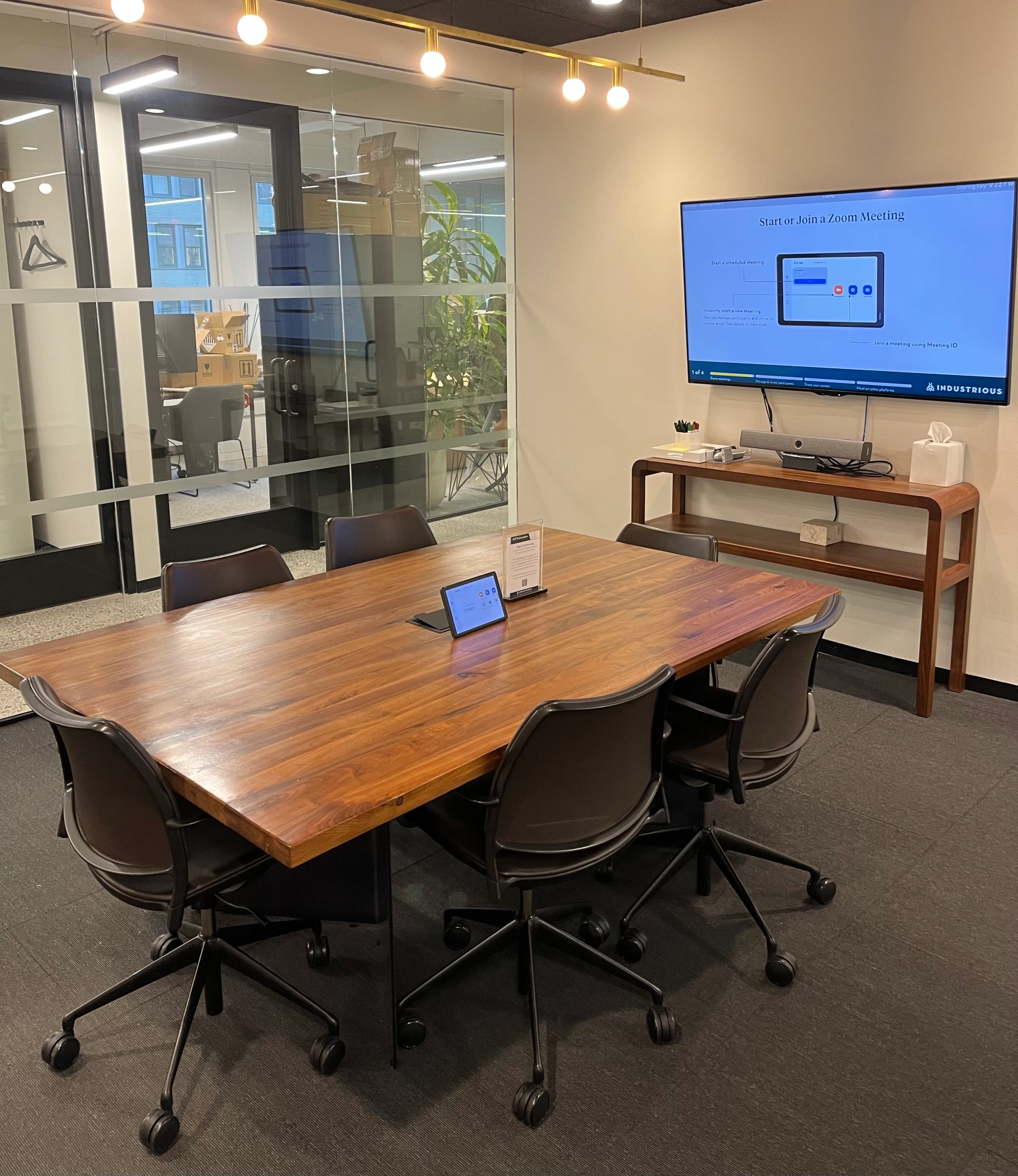 A meeting room in New York with a table and chairs and a TV.