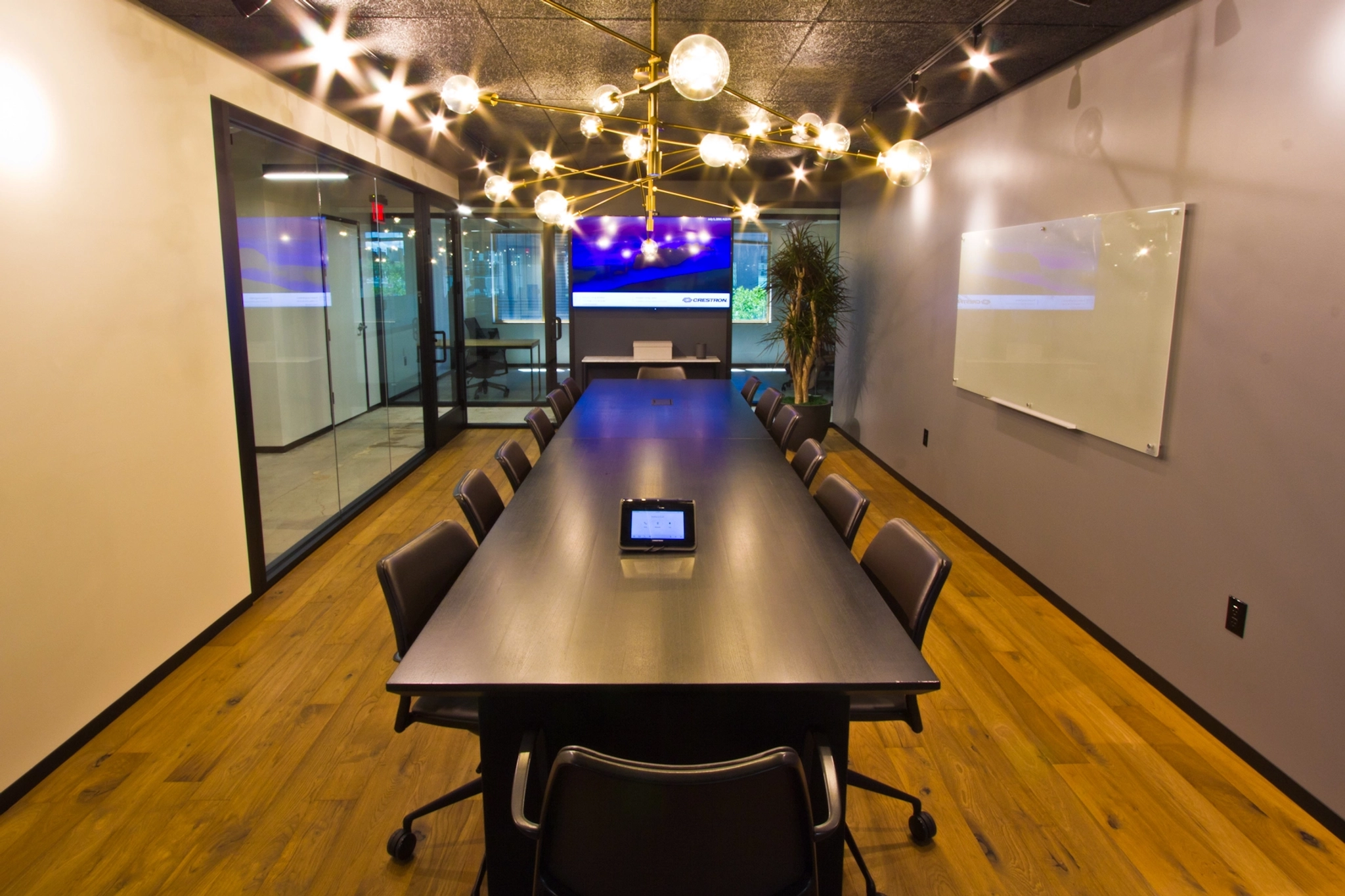 A sleek conference room in an office space featuring a black table and chairs.