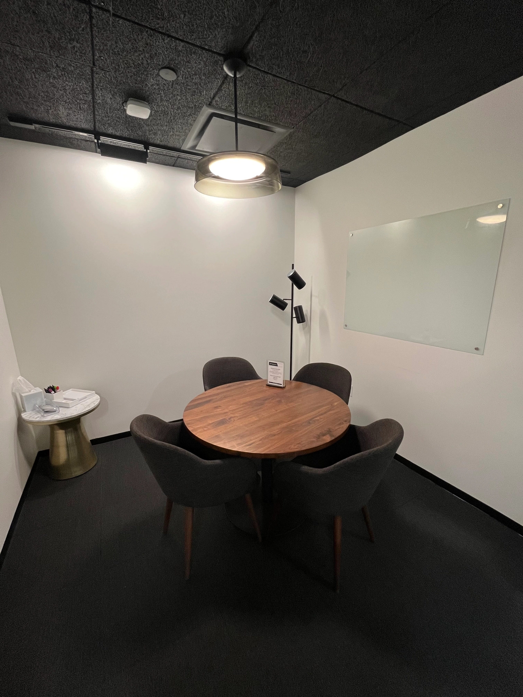 Une pièce en noir et blanc avec une table et des chaises, parfaite pour un espace de coworking.