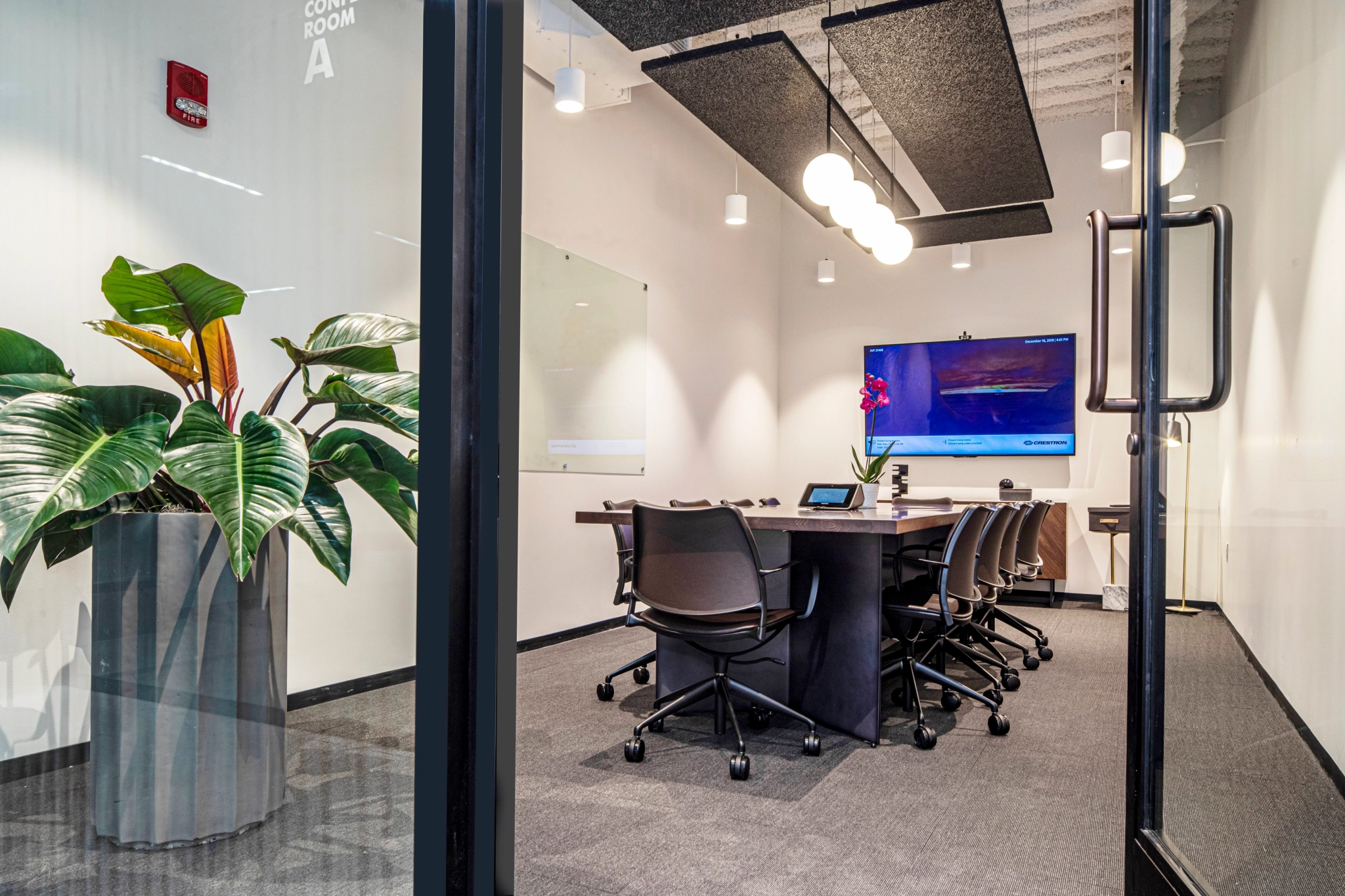 A Pittsburgh office meeting room with a glass door and a plant.