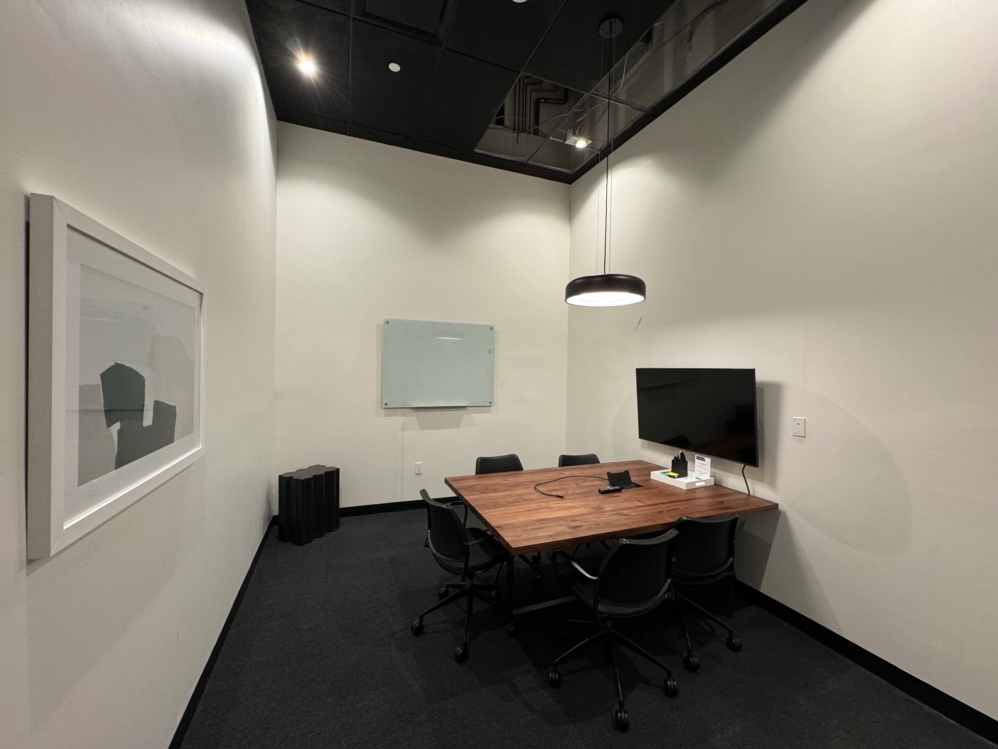 A coworking space outfitted with a conference room table and chairs.