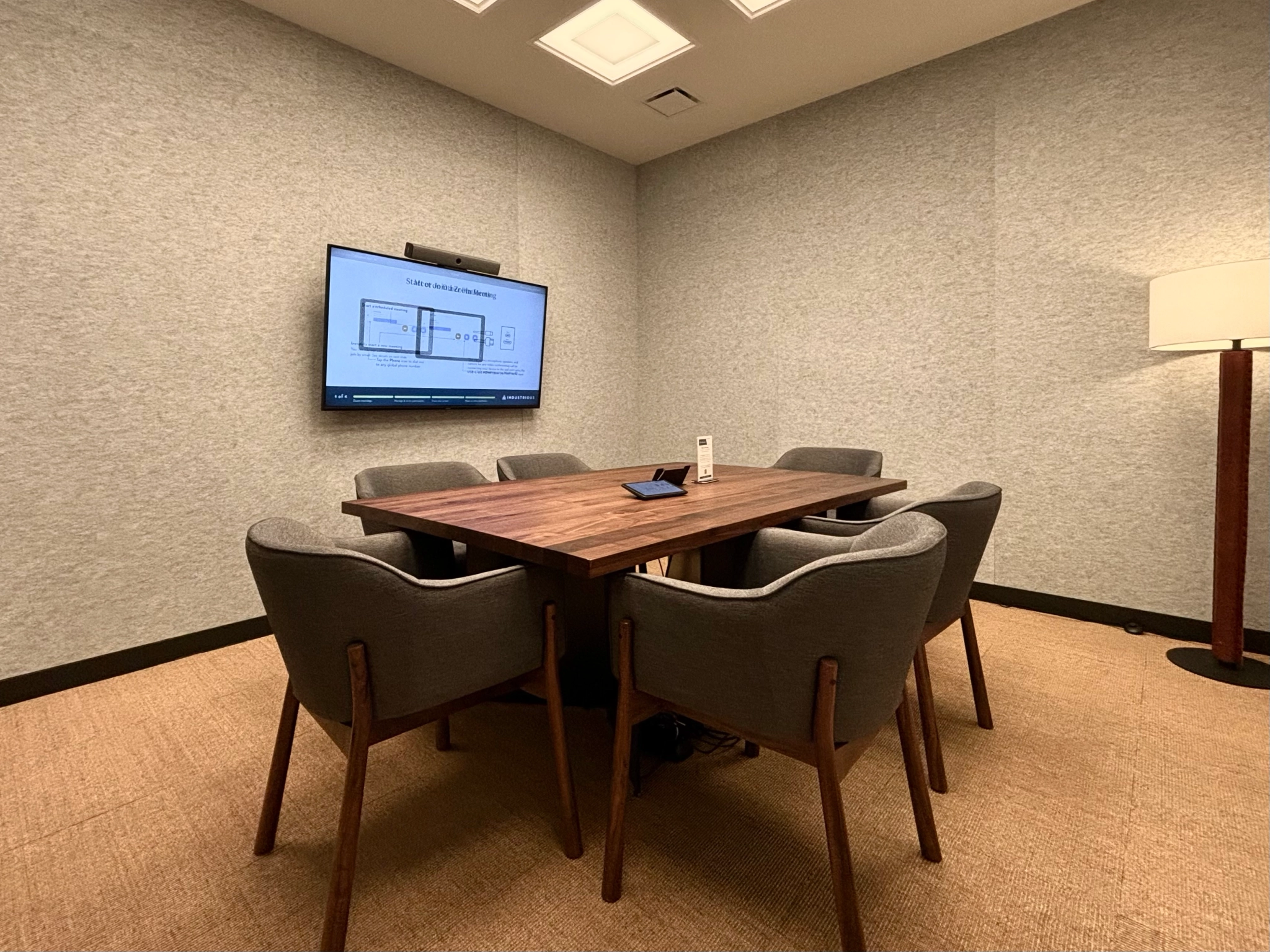 Une salle de réunion de coworking à Seattle avec une table, des chaises et une télévision.