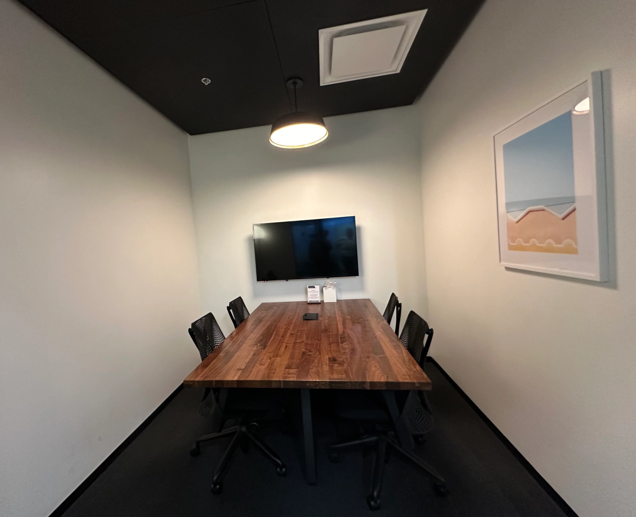 A coworking space with a wooden table and chairs in an office.