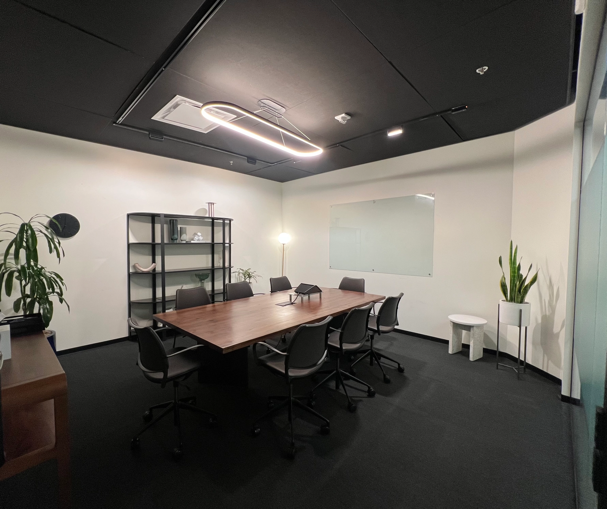 A black and white conference room in a coworking space with a table and chairs.