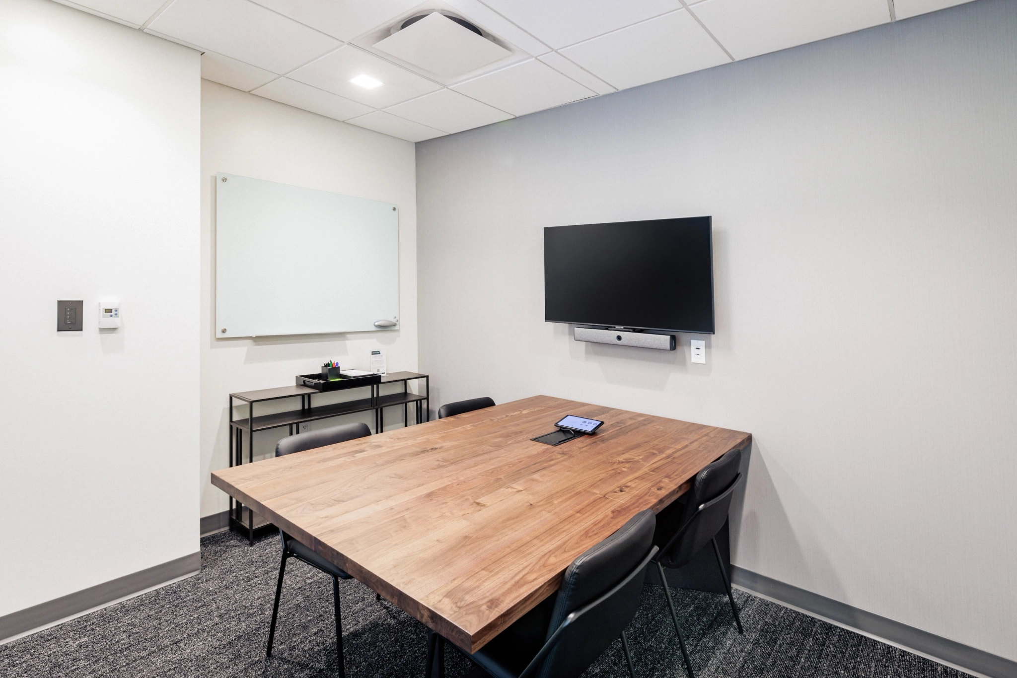 A coworking space equipped with a conference table and a TV.