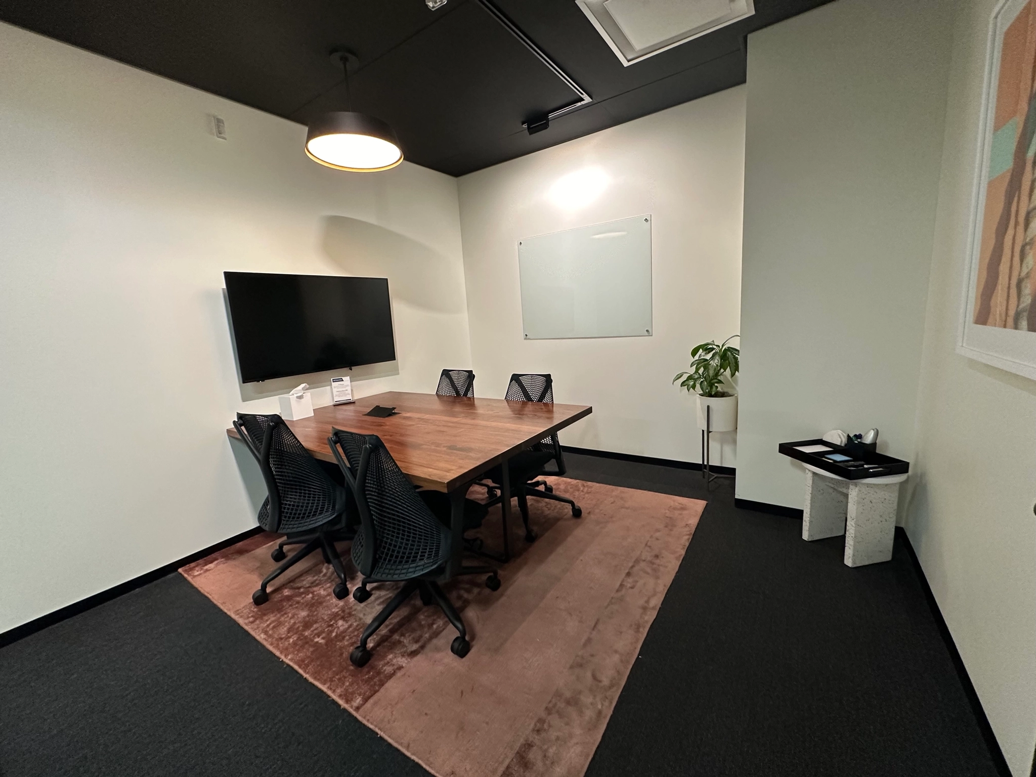 A coworking workspace in Costa Mesa equipped with a conference room featuring a table and chairs.