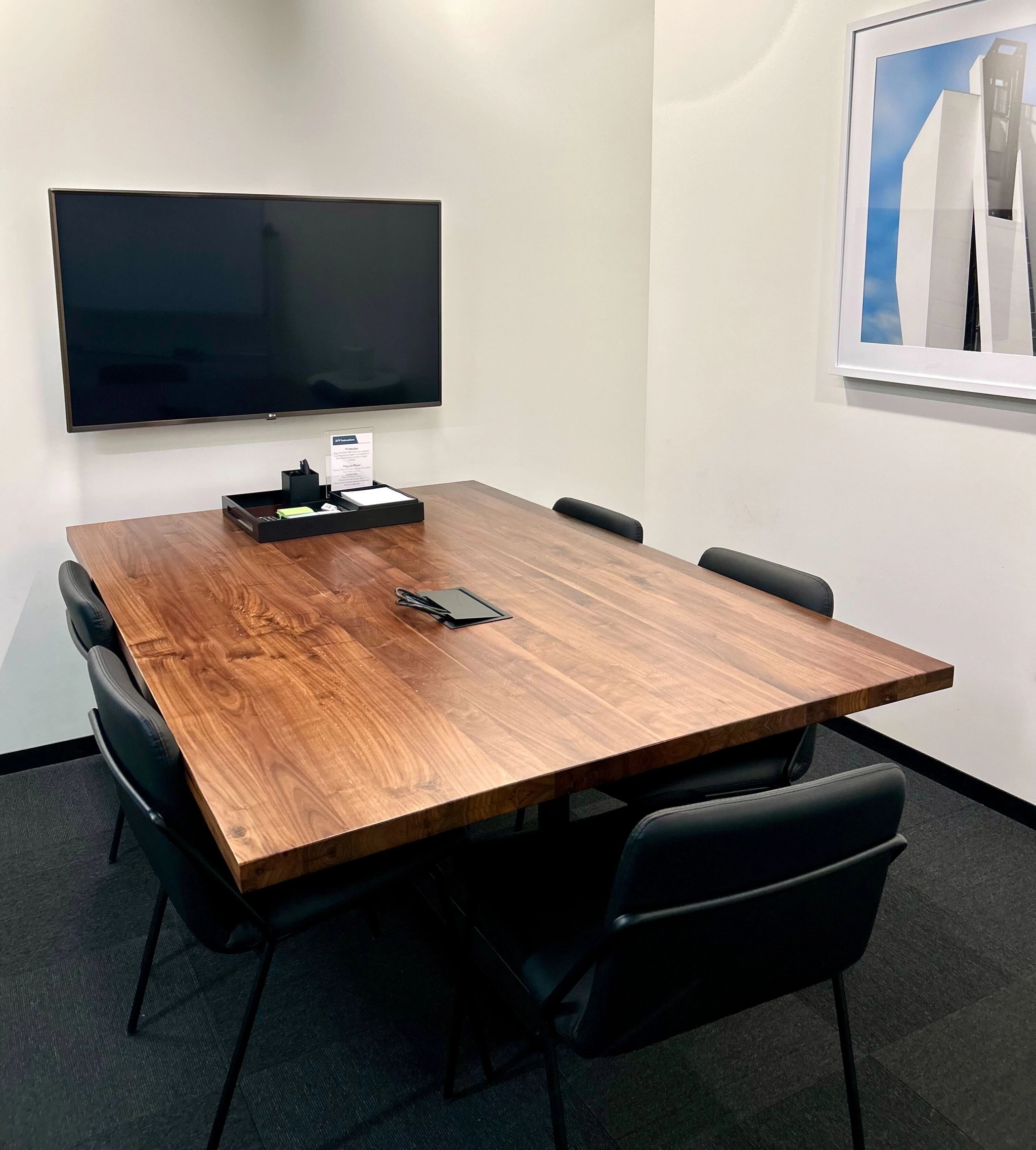 A coworking space in Boston equipped with a wooden table and chairs, providing a comfortable workspace for individuals and teams.