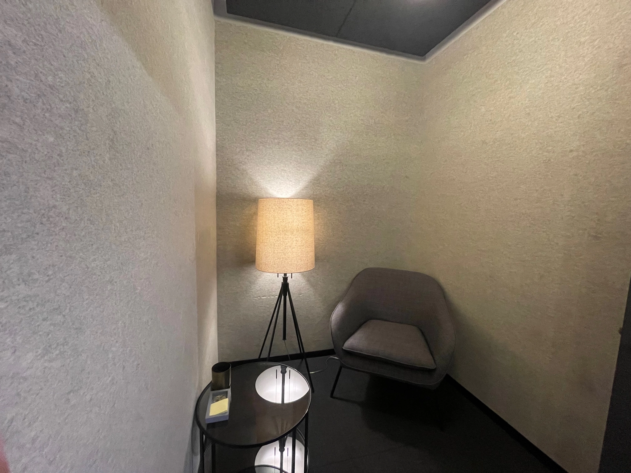 A small coworking room in Dallas with a chair and a lamp, suitable for meetings.