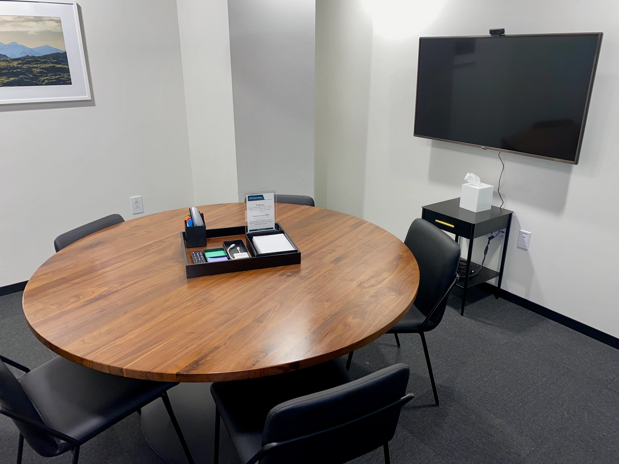 A modern conference room in Boston with a round table and comfortable chairs, designed for collaborative workspace.