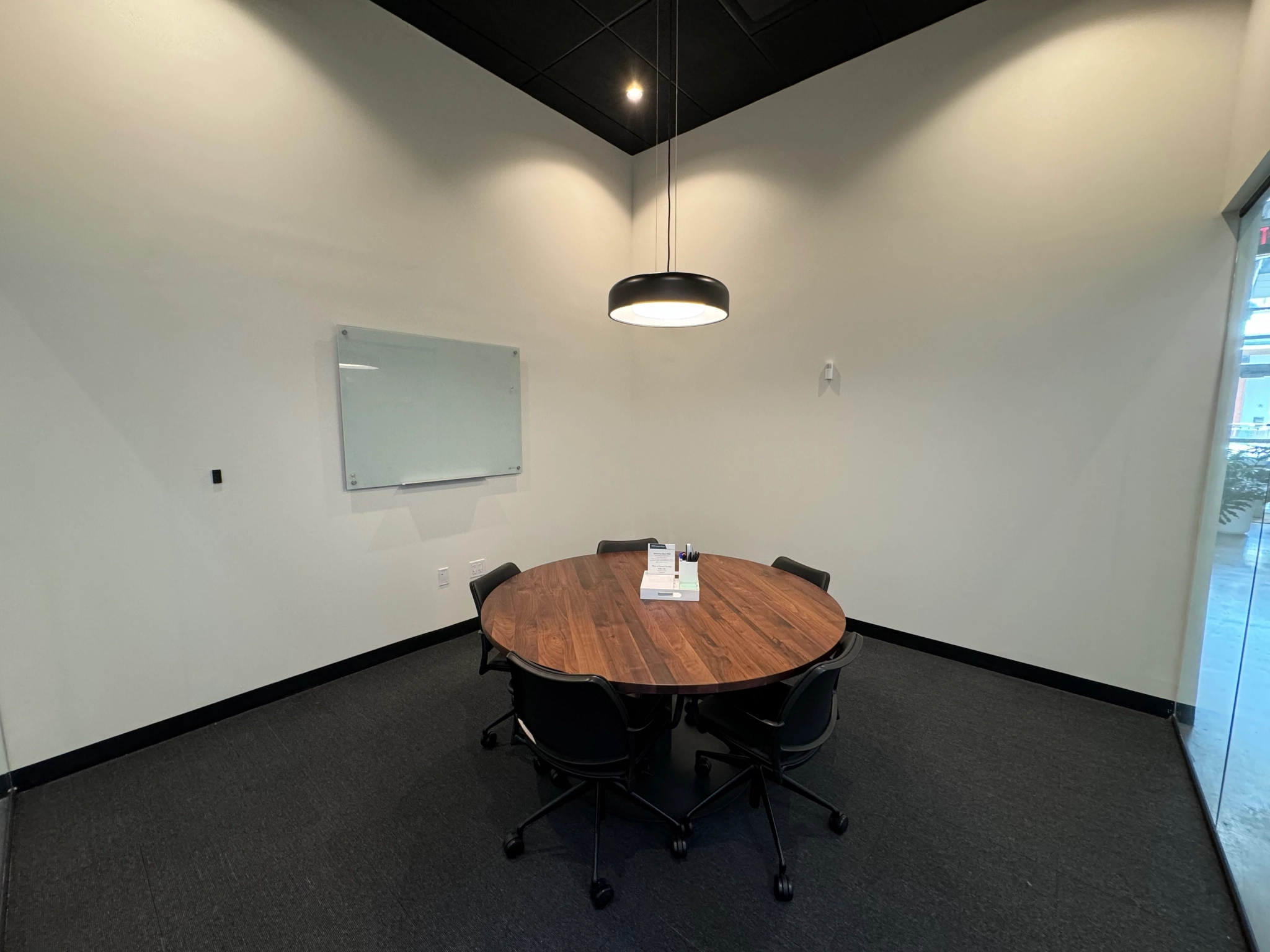 A conference room with a round table and chairs, perfect for office meetings or coworking.