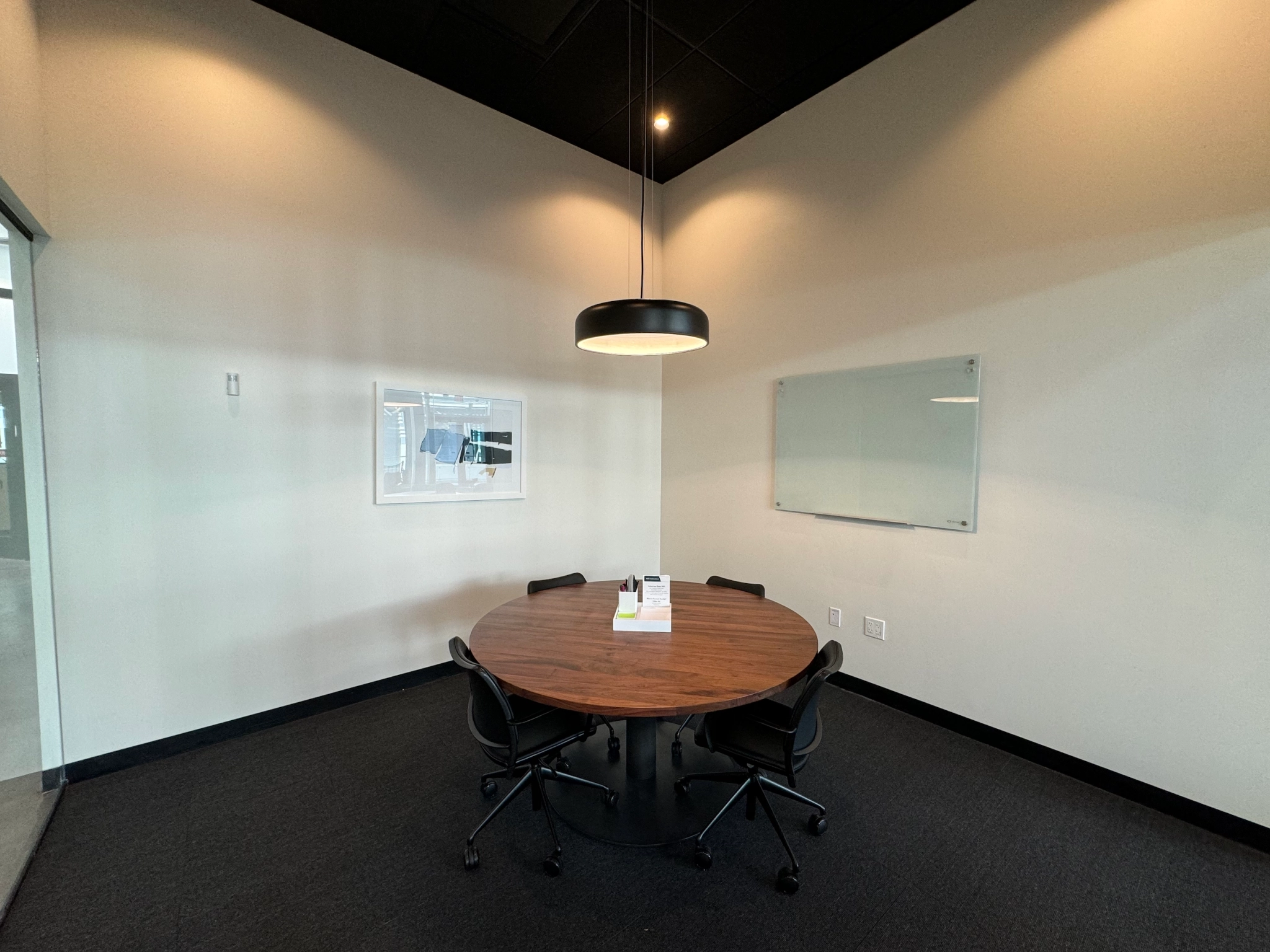 A conference room with a round table and chairs suitable for meetings in an office space.