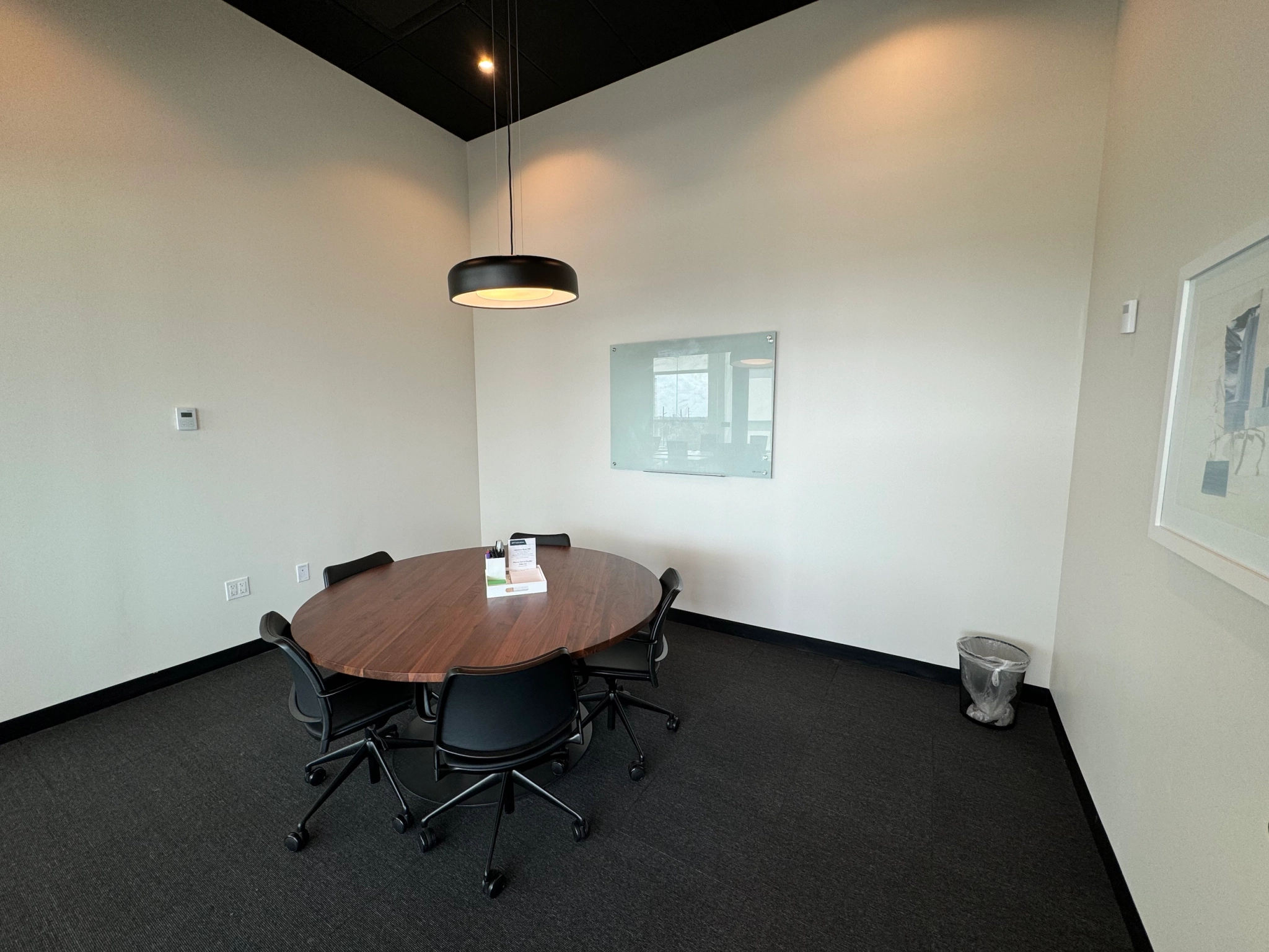 Une salle de réunion de coworking avec table ronde et chaises.