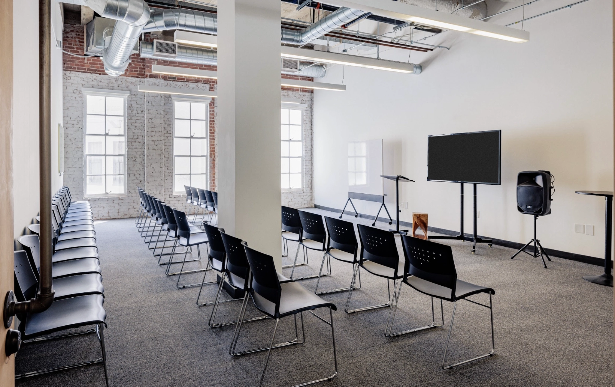 Une salle de réunion à San Francisco avec des rangées de chaises et une télévision.