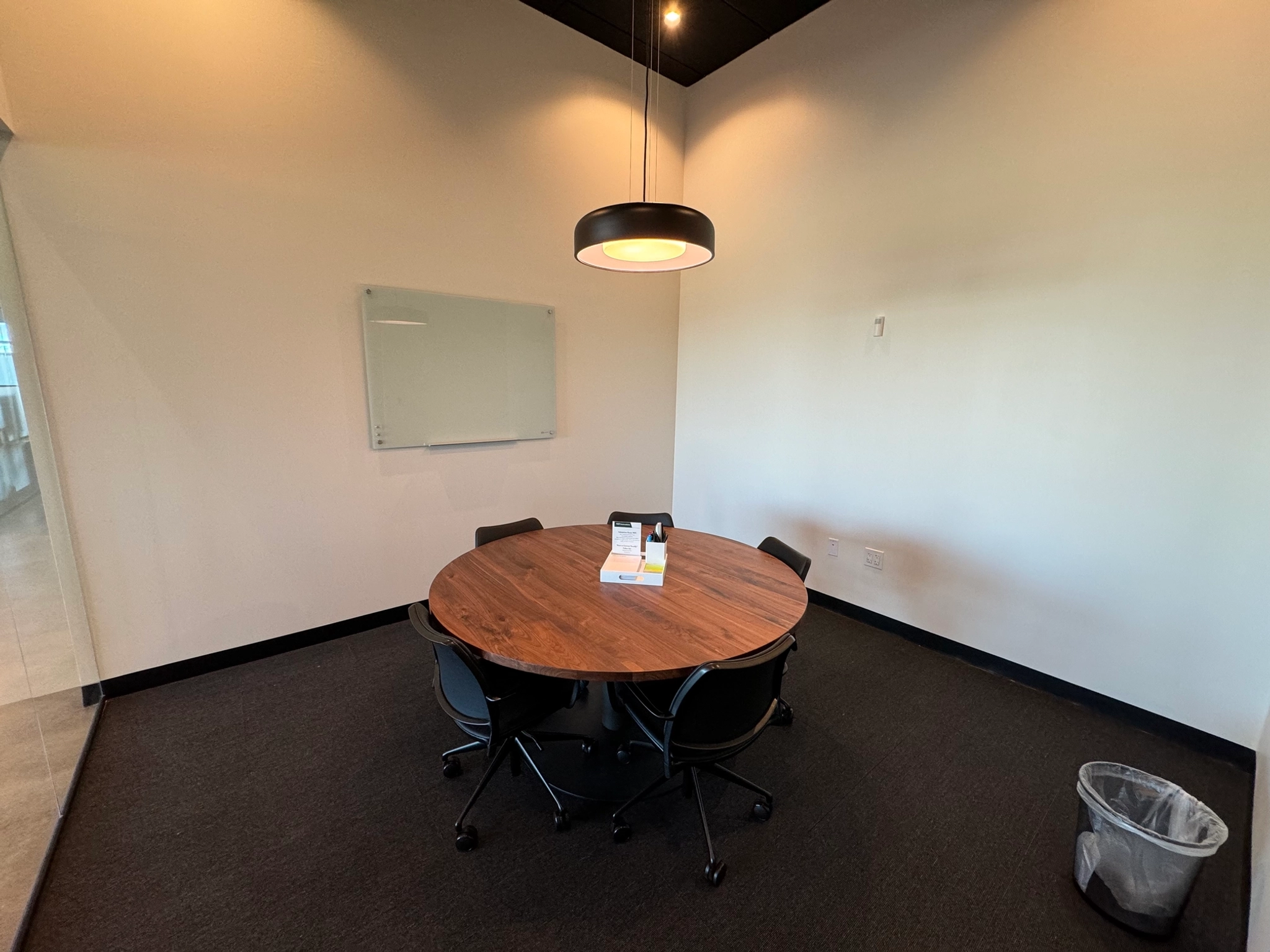 An office conference room with a round table and chairs.