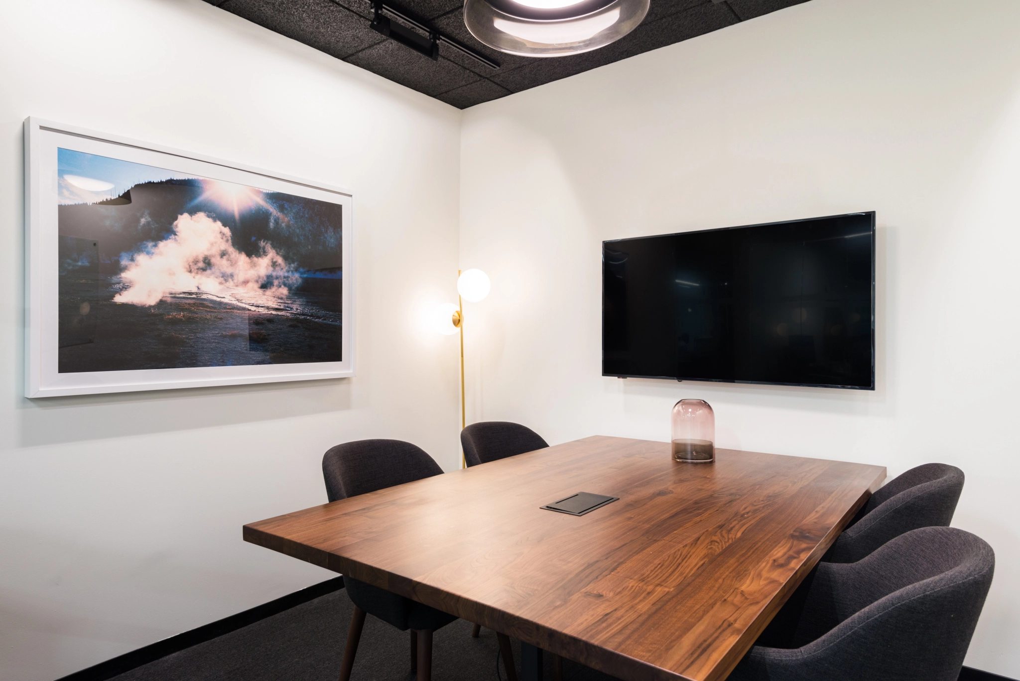 Een vergaderruimte in New York met een tafel, stoelen en een televisie.