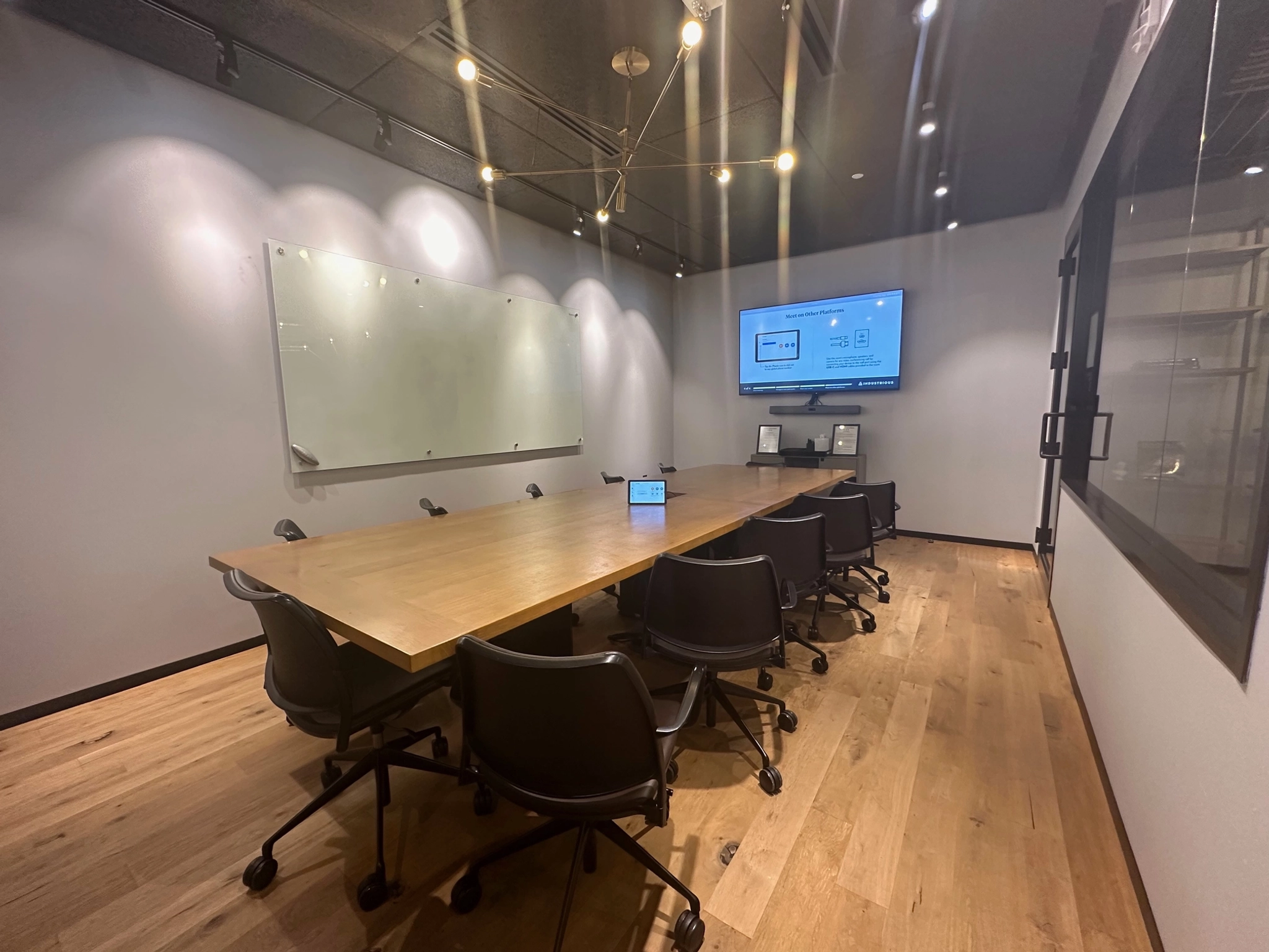 Une salle de conférence spacieuse avec une grande table et des chaises pour des réunions productives dans un bureau professionnel.