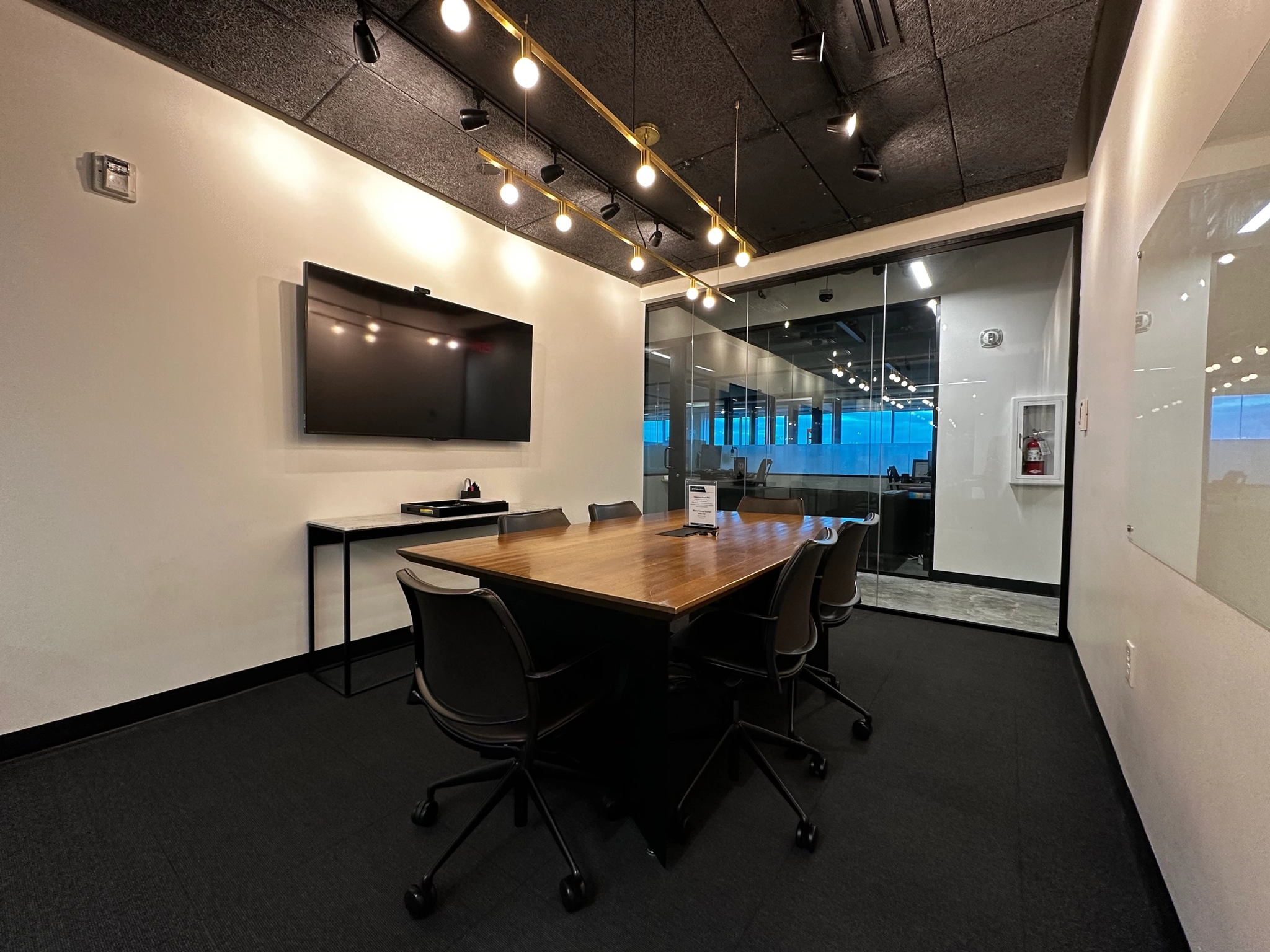 Un bureau de coworking équipé d'une salle de conférence spacieuse meublée d'une table et de chaises.