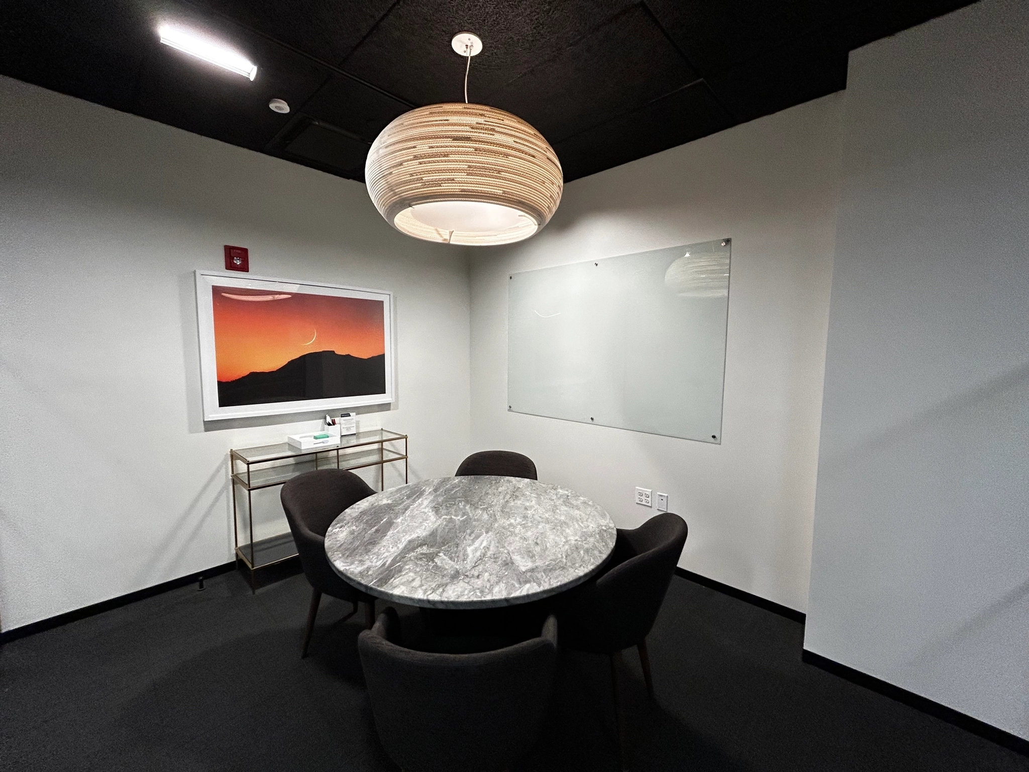 Un bureau salle de réunion avec une table ronde et des chaises.