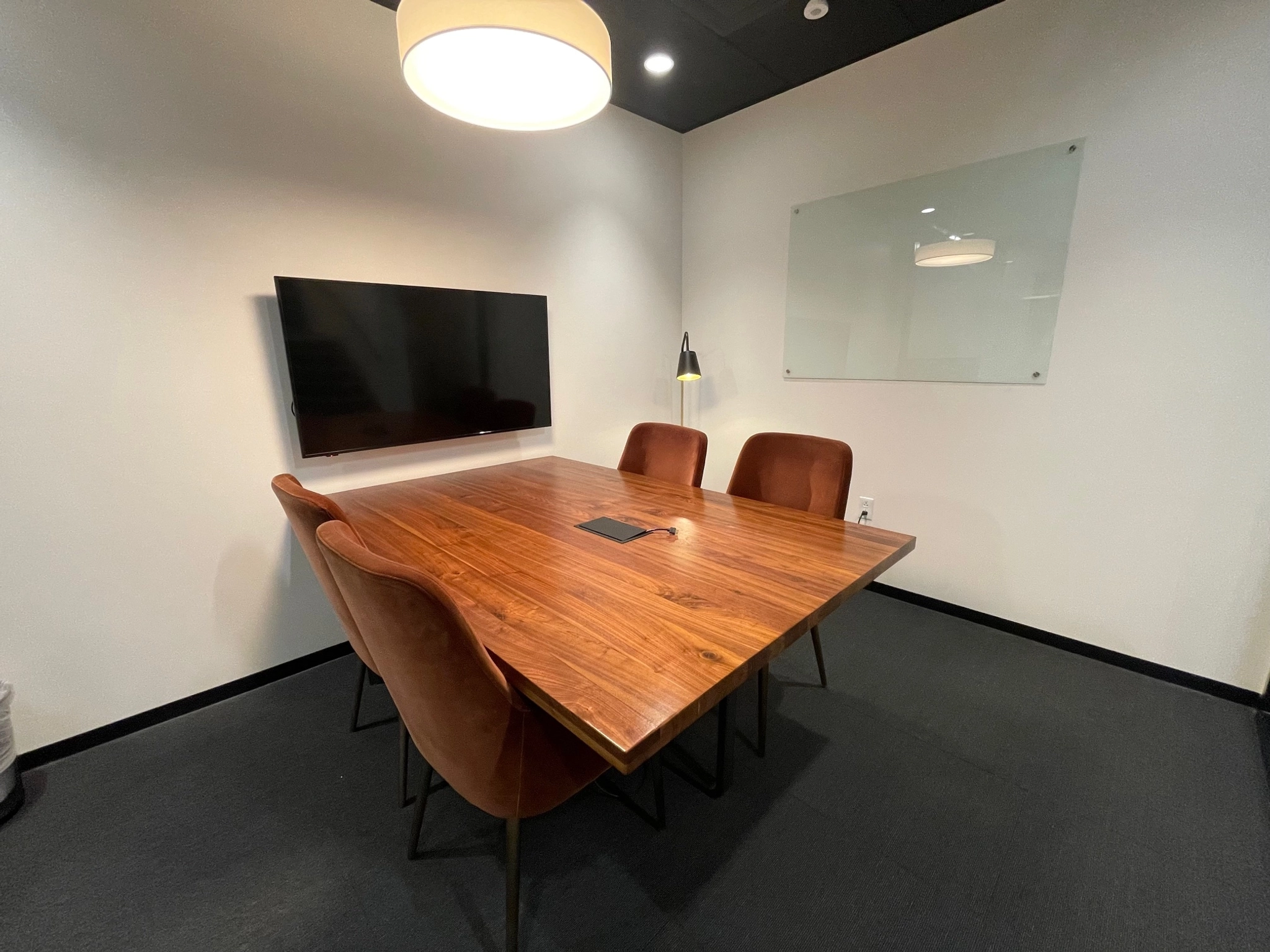 A conference room with a wooden table and chairs, suitable for meetings and office work.