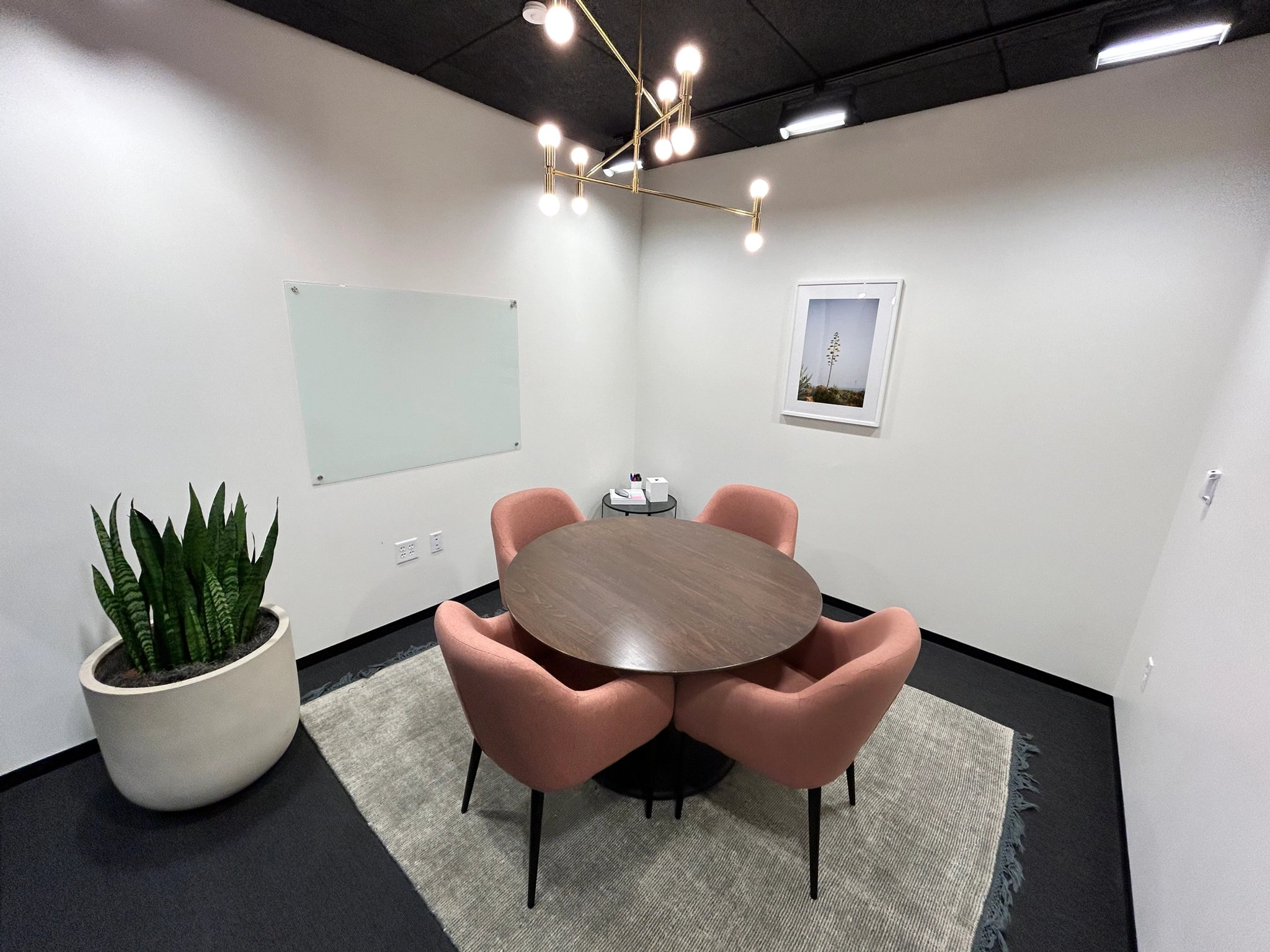 Une salle de réunion Evanston avec table et chaises, offrant un espace de travail fonctionnel.