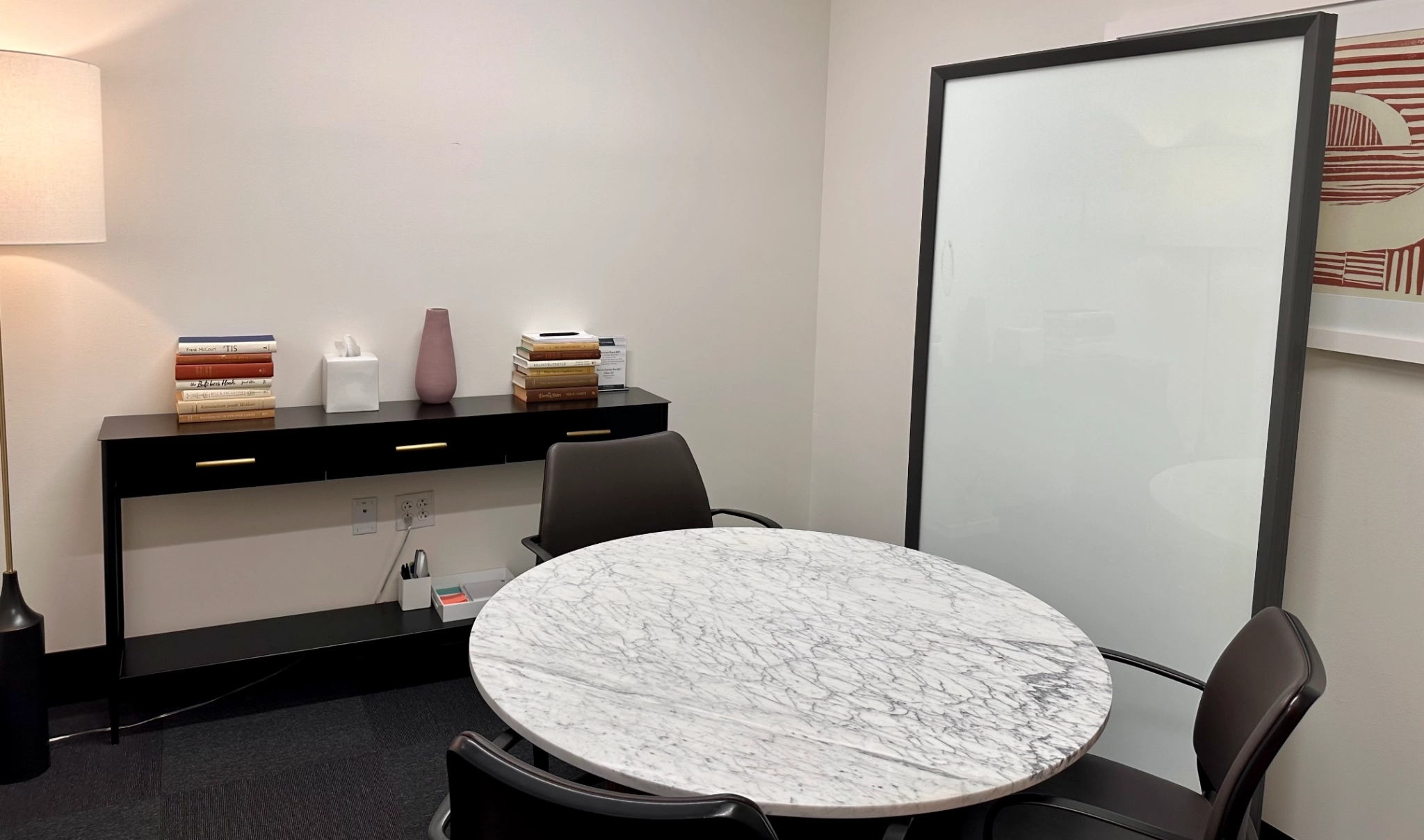 A coworking meeting room in Boston furnished with a table and chairs.