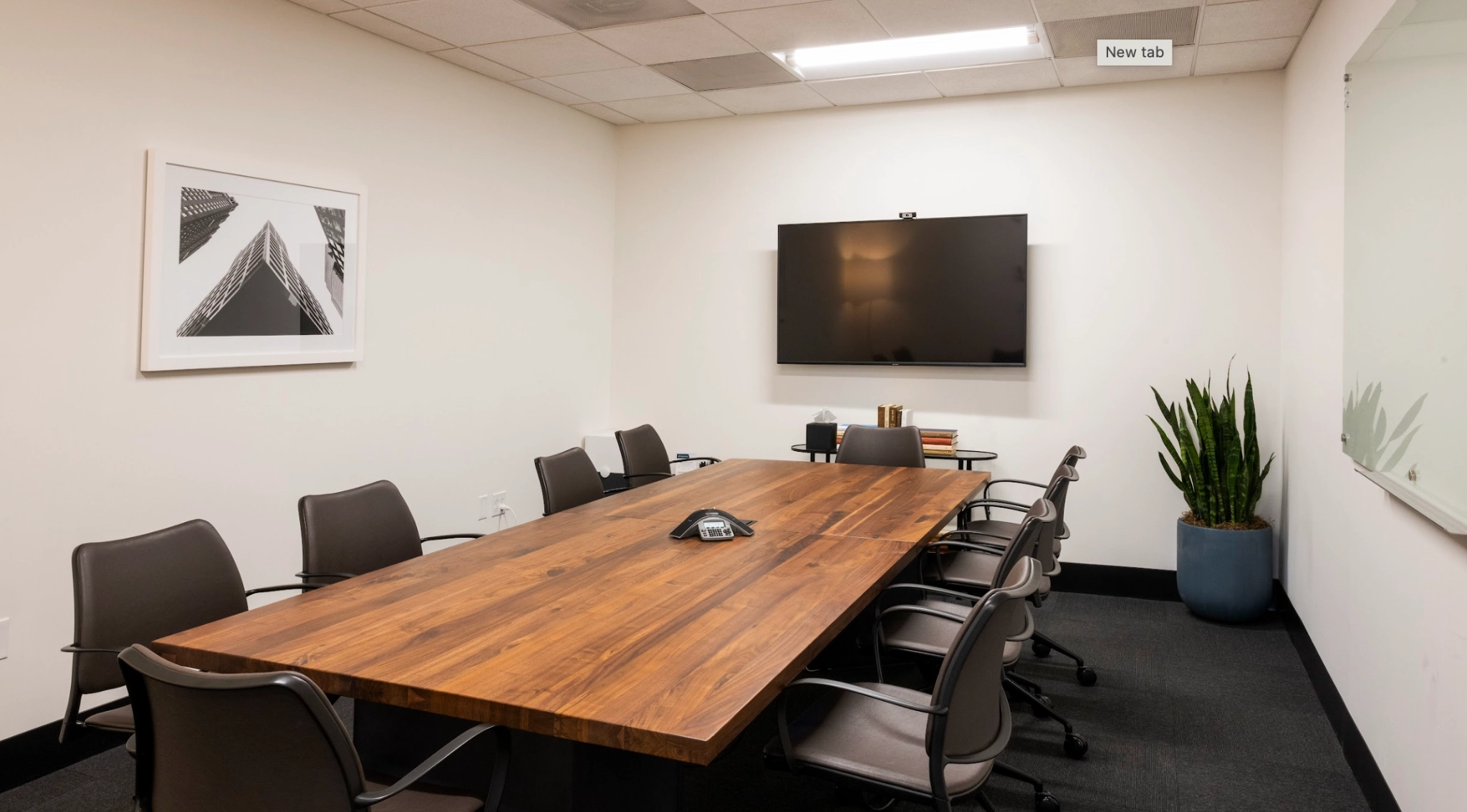 Un bureau salle de conférence meublé d'une table et de chaises en bois.