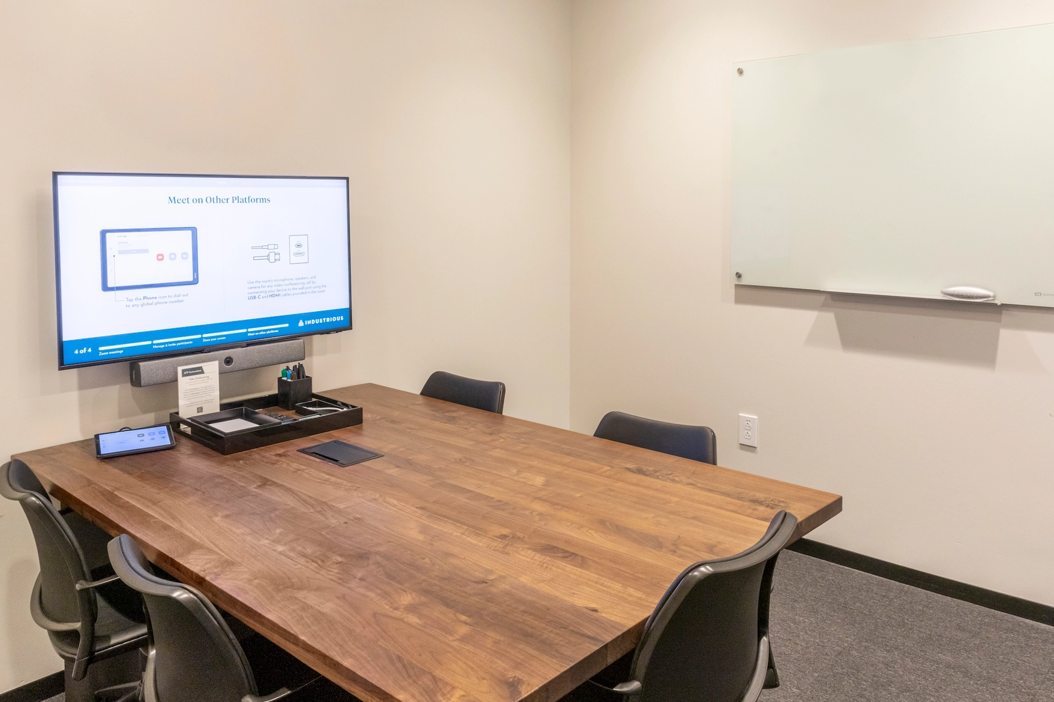 A workspace with a large tv on the wall.