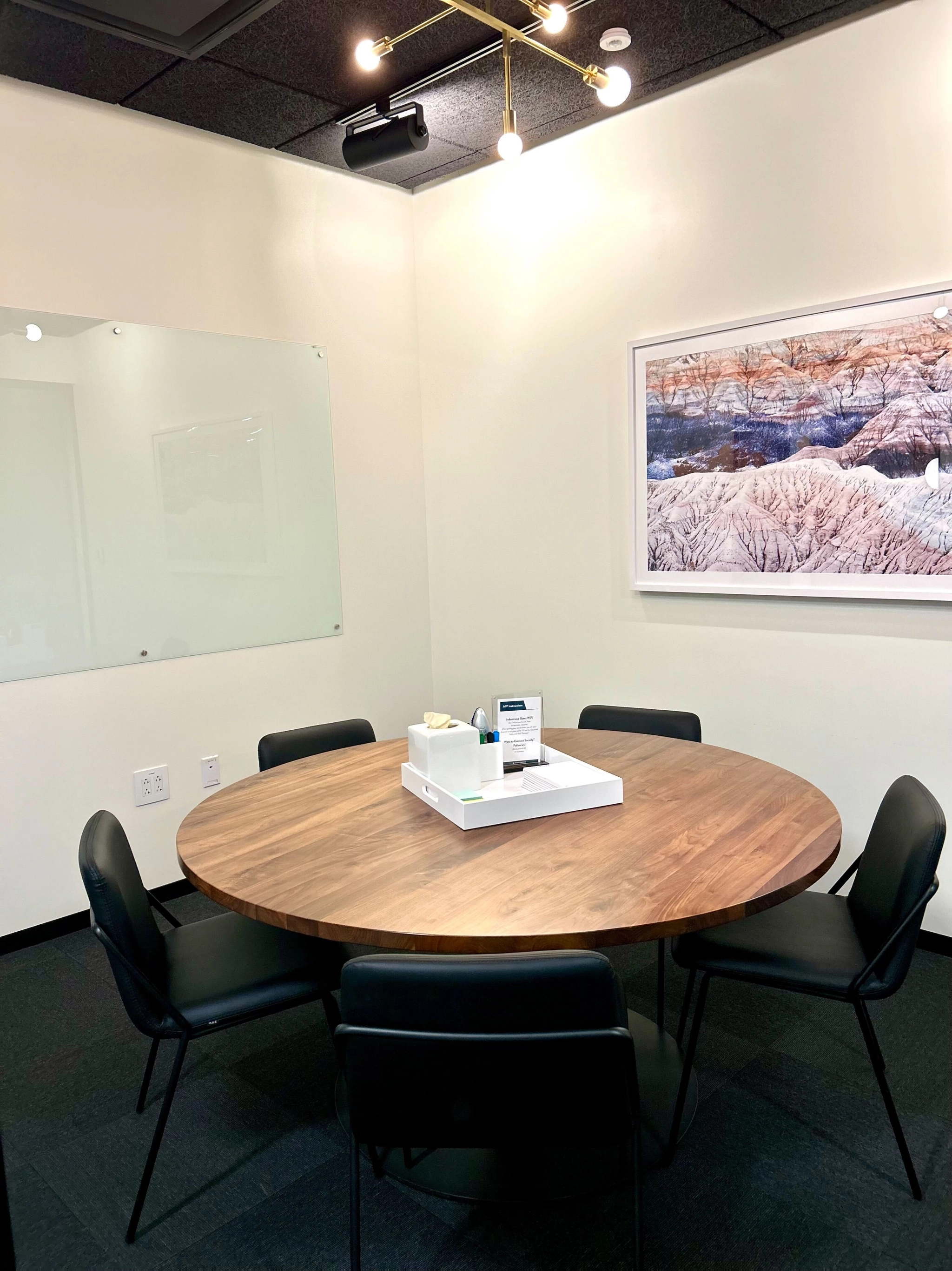 Une salle de conférence de bureau à Boston dotée d'une table ronde et de chaises, créant un espace de travail collaboratif.