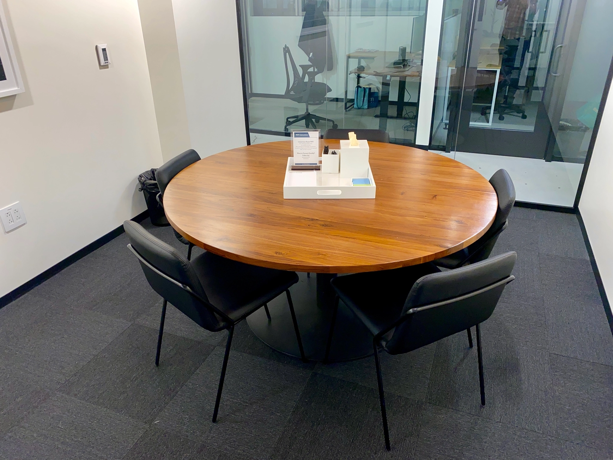 Une salle de réunion à Boston équipée d'une table ronde et de chaises, offrant un espace de travail idéal pour des discussions collaboratives.