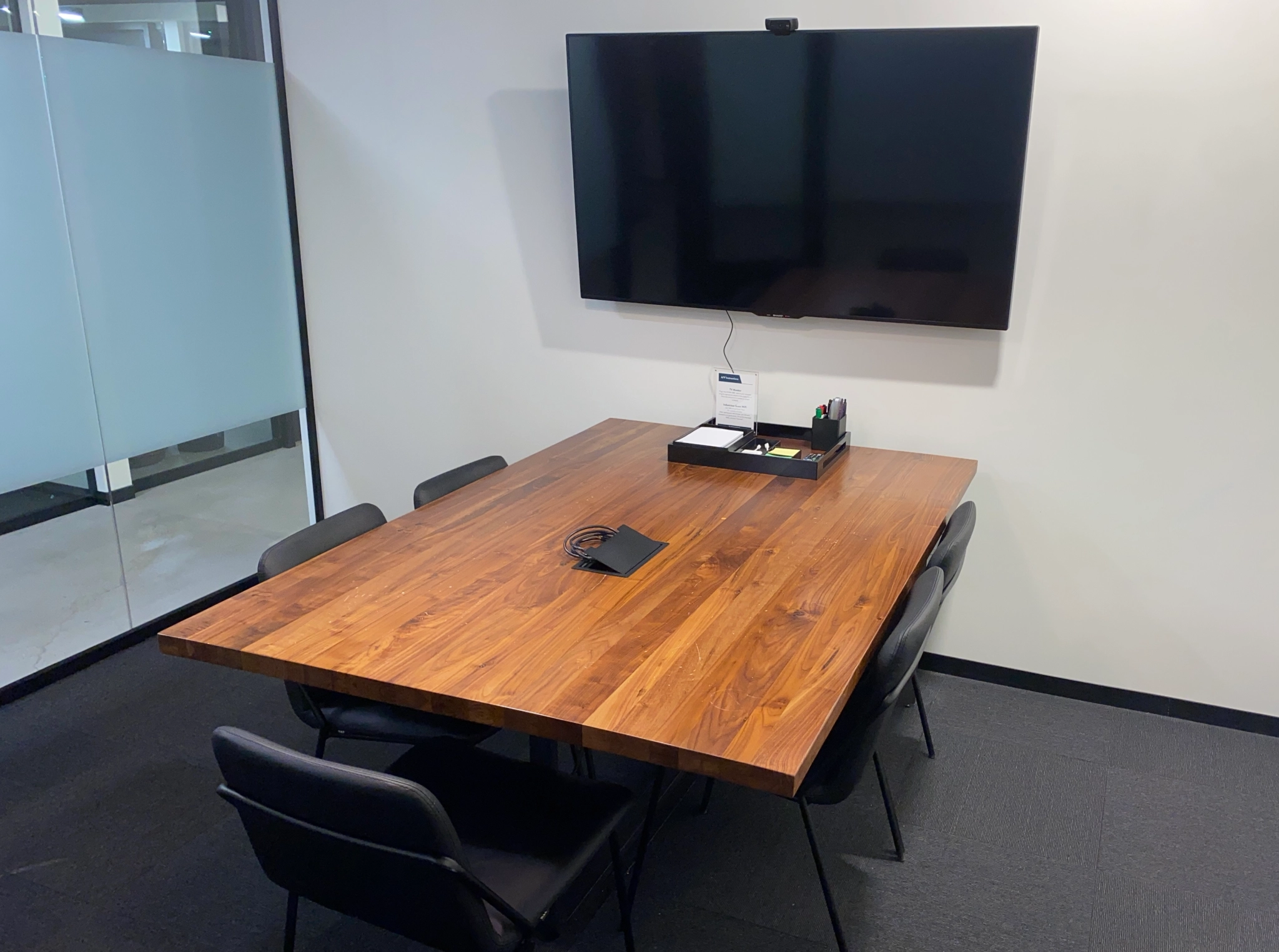 Un espace de travail de coworking à Boston comprenant une table de conférence avec une télévision.