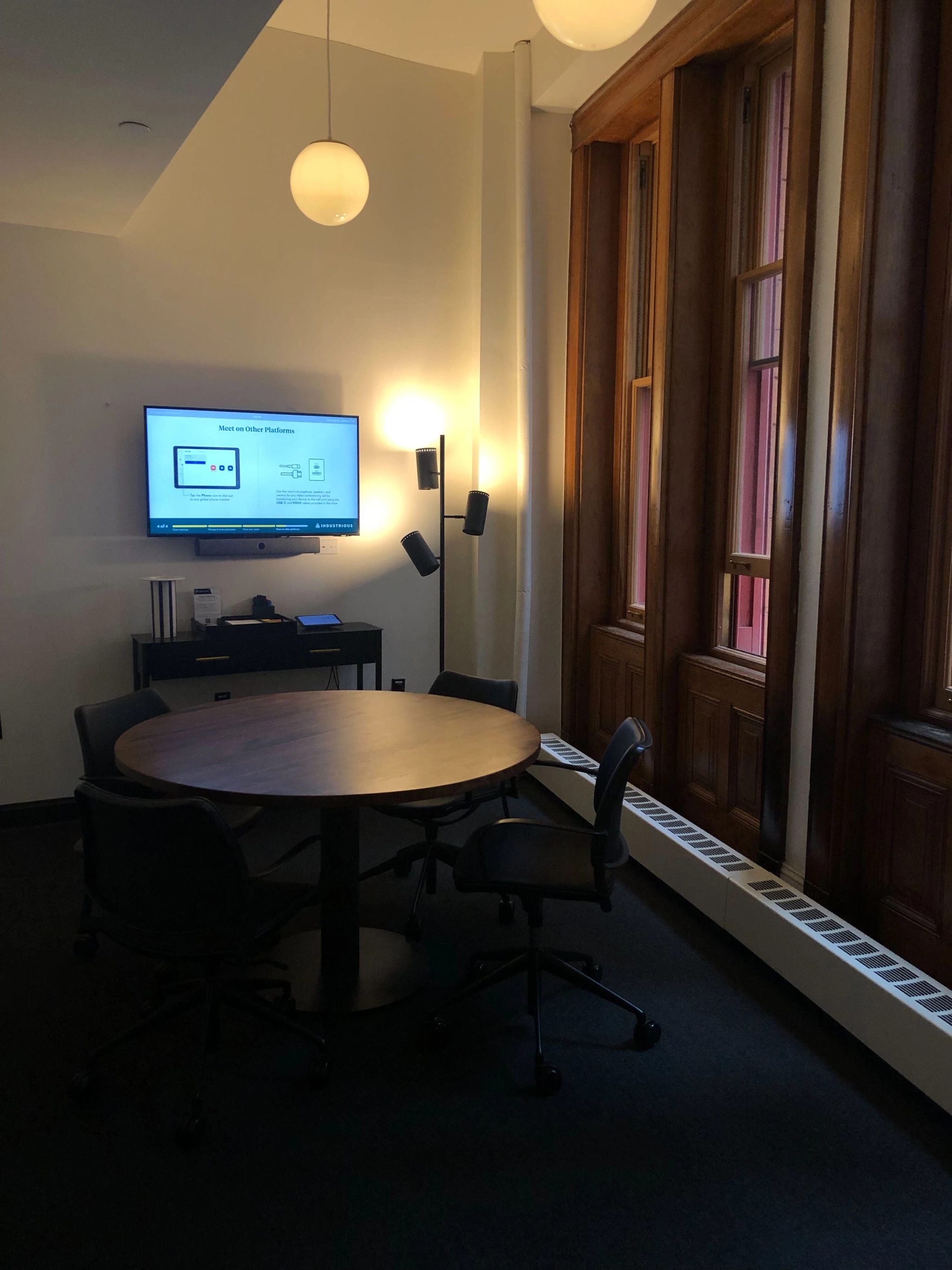 Een vergaderruimte in een kantoor in New York met een tafel, stoelen en een televisie.