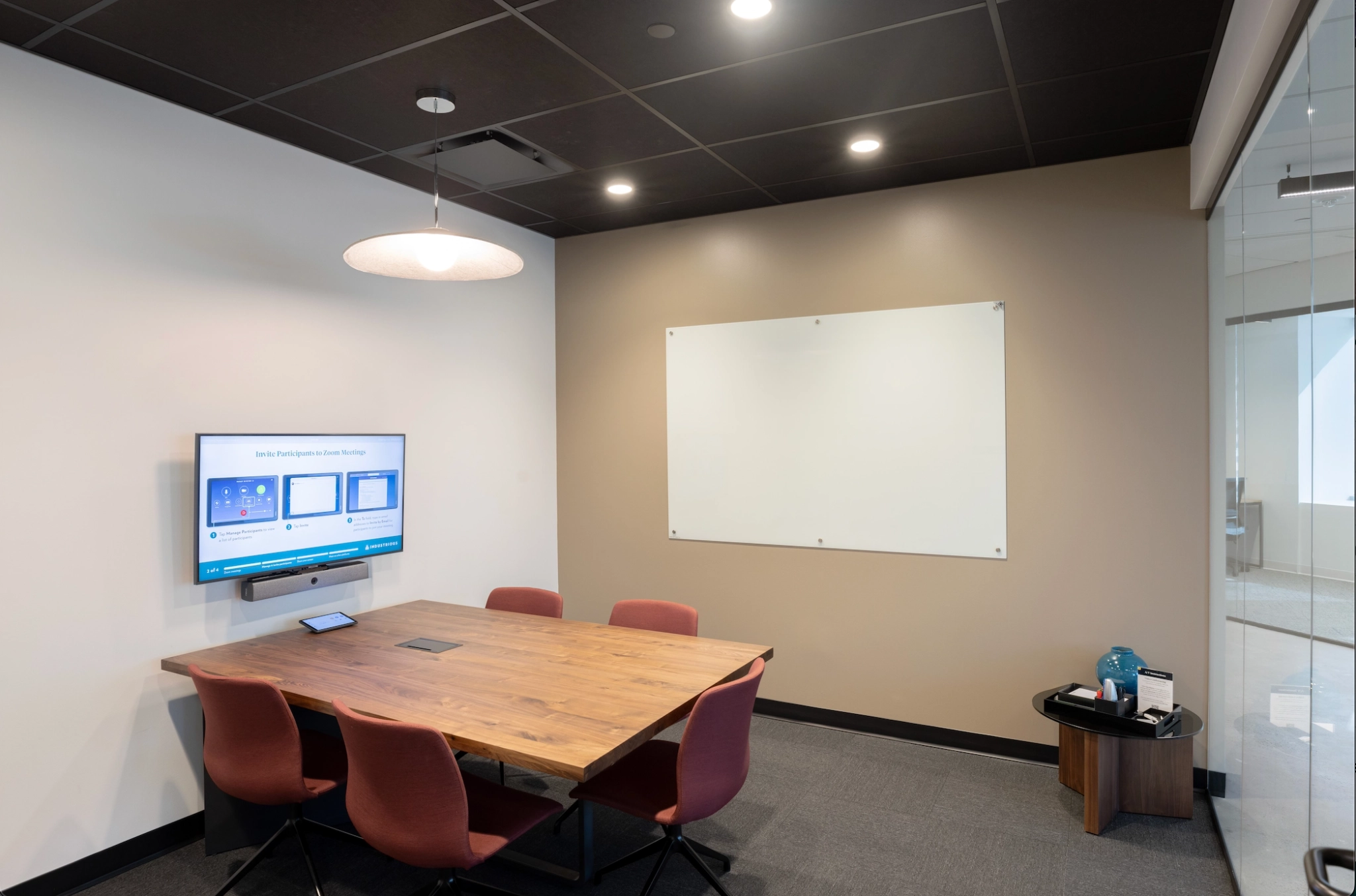 A meeting room in Houston with a table, chairs, and a TV.