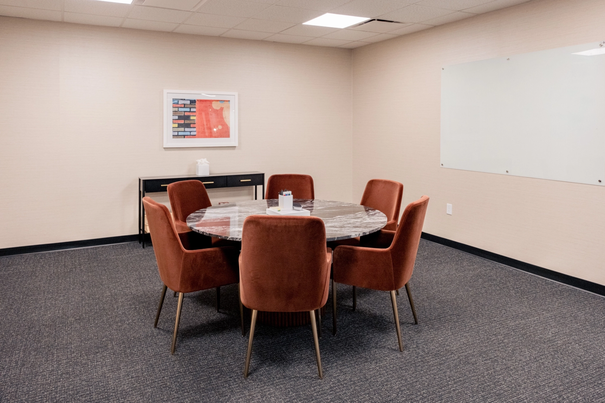 A coworking space with a round table and chairs.