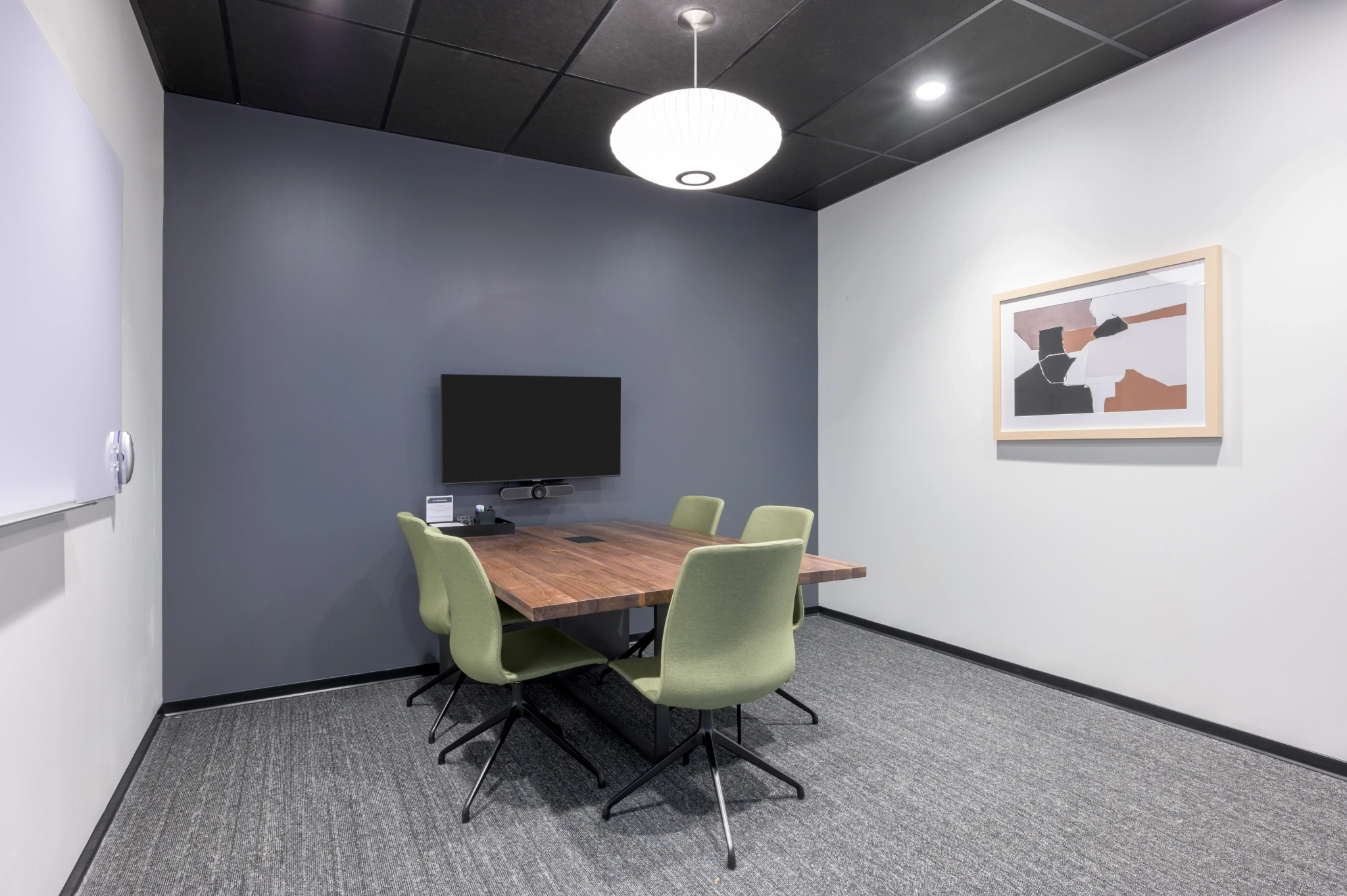 A meeting room with a table and chairs.