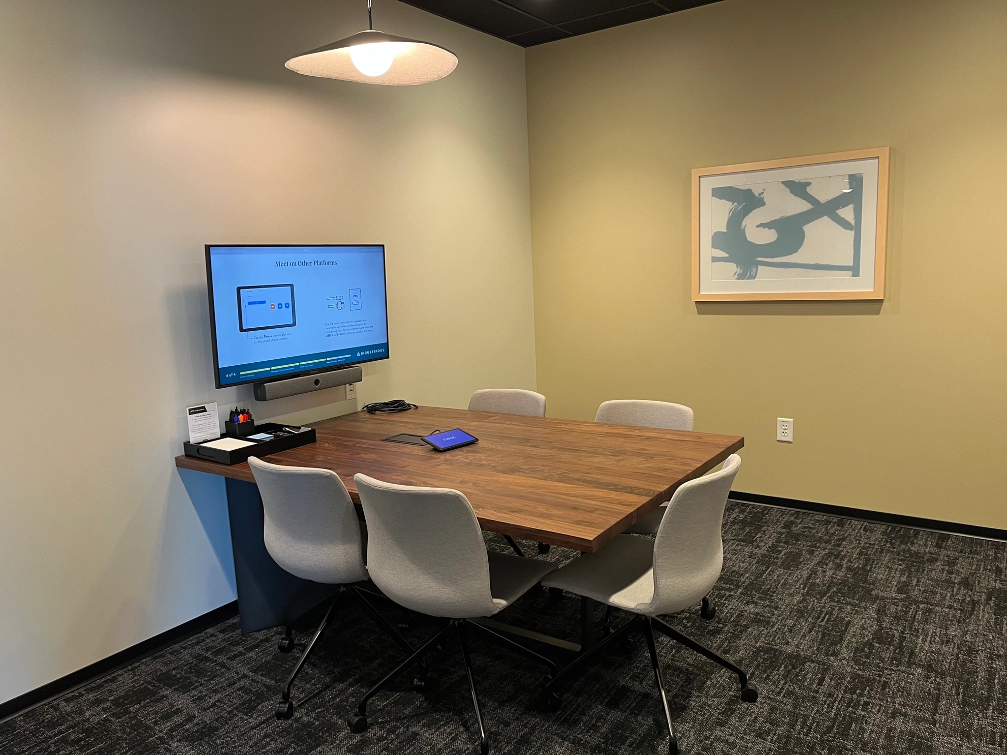 A coworking space in Atlanta equipped with a table, chairs, and a TV for seamless collaborative meetings and presentations.