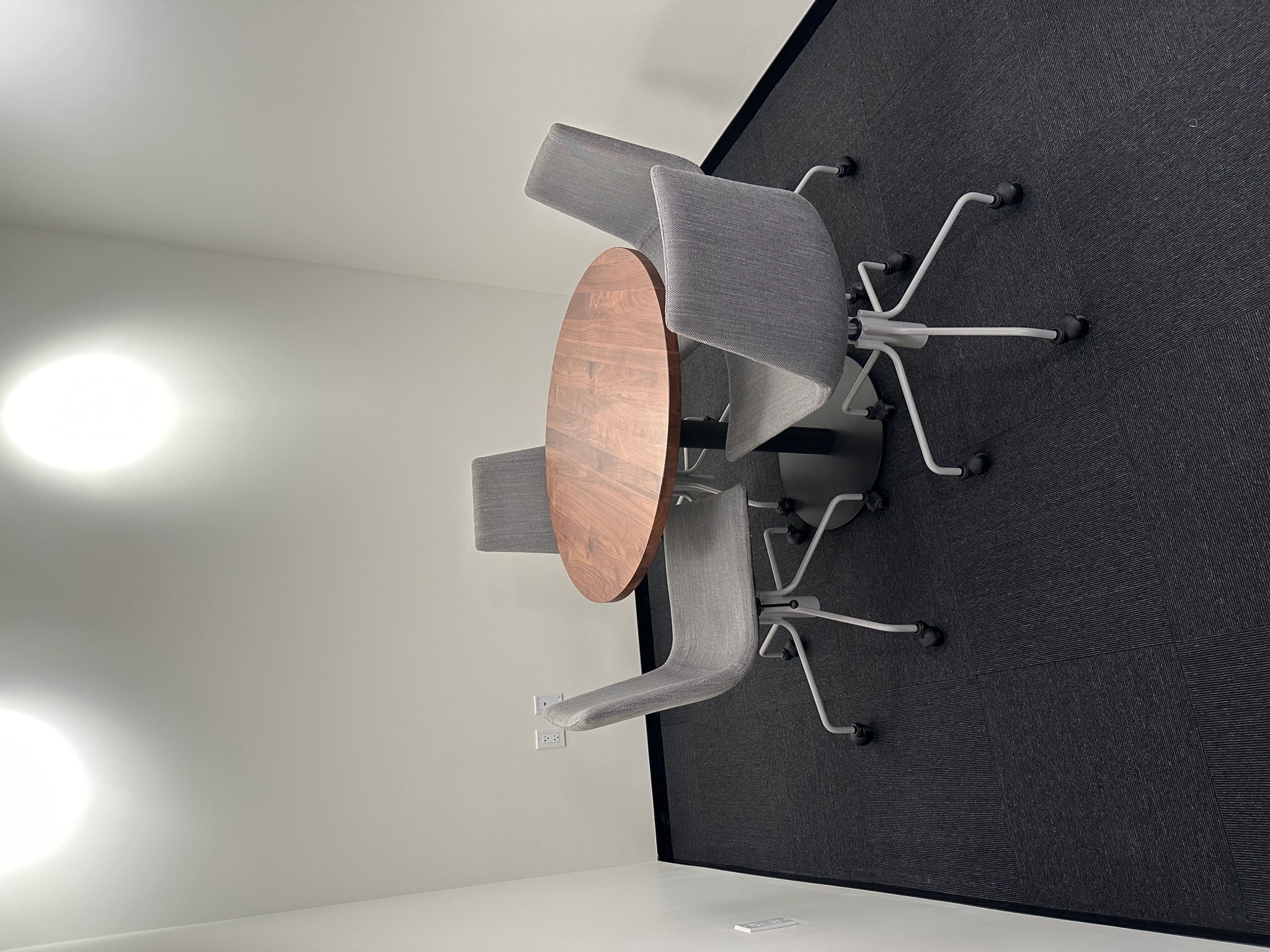 A 3D rendering of a conference room in an office space featuring a table and chairs for meetings.