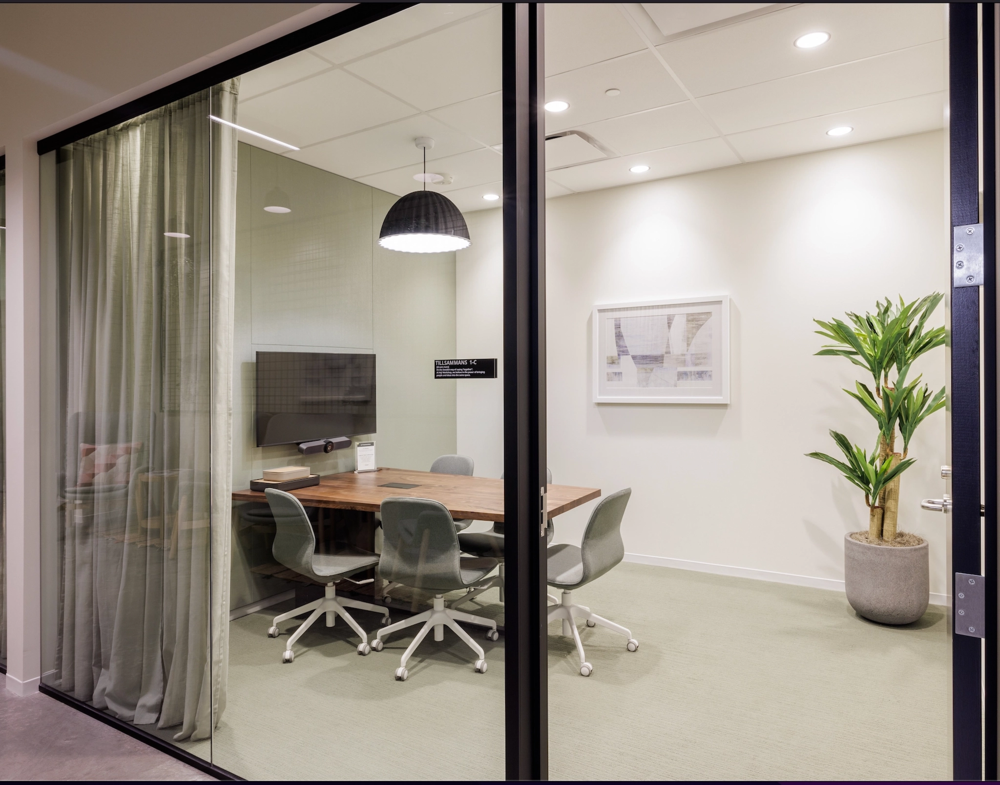 Une salle de réunion avec portes vitrées et une table dans un bureau.