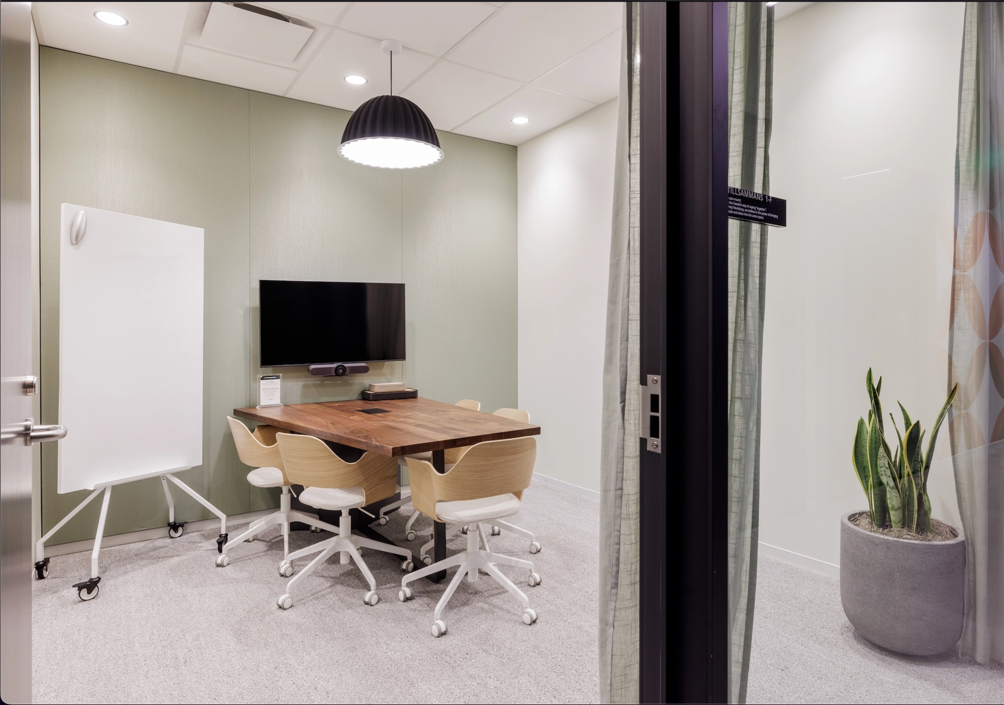 Une salle de réunion dans un bureau de San Francisco avec une table, des chaises et une télévision.