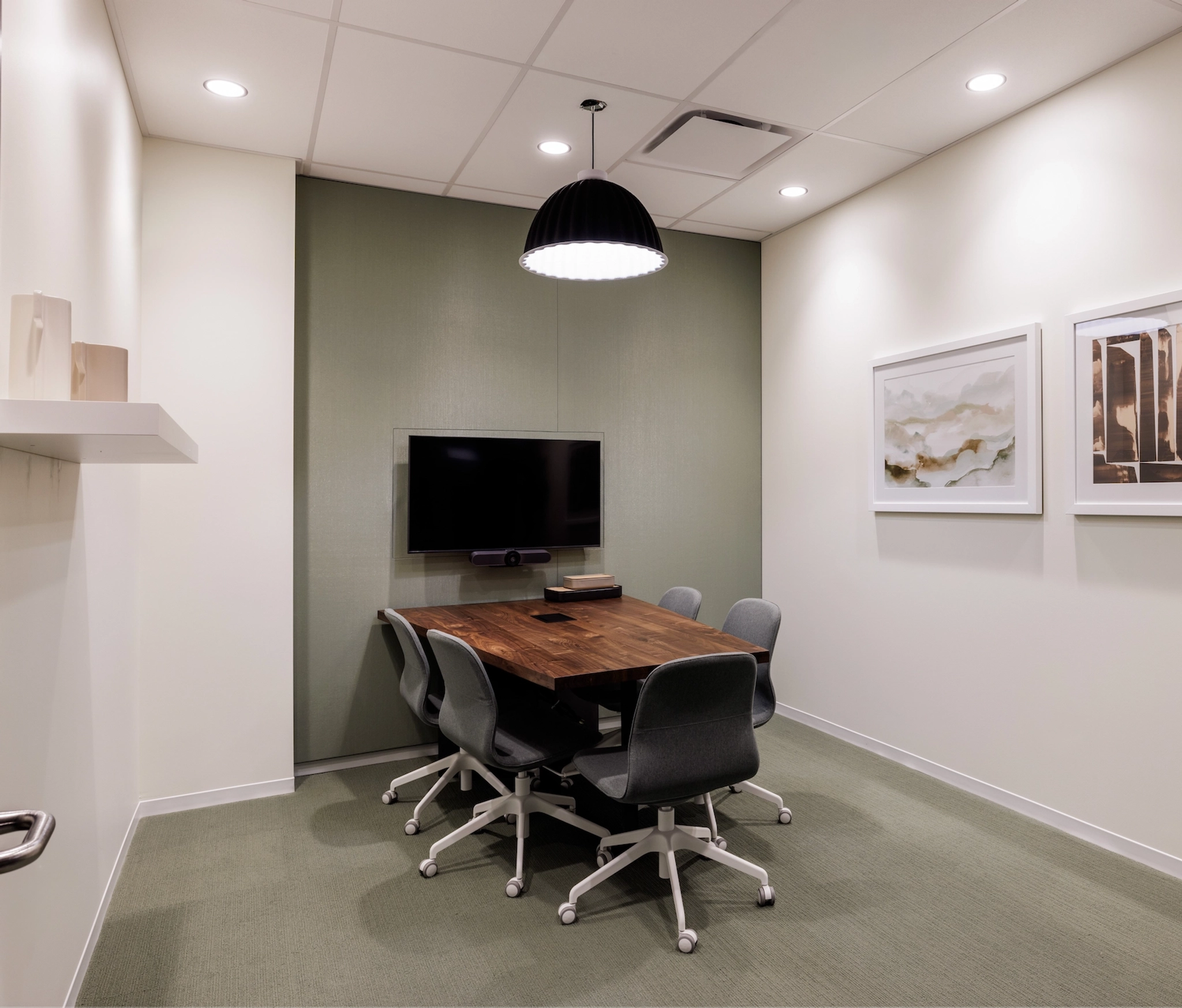 A meeting room with a table and chairs.