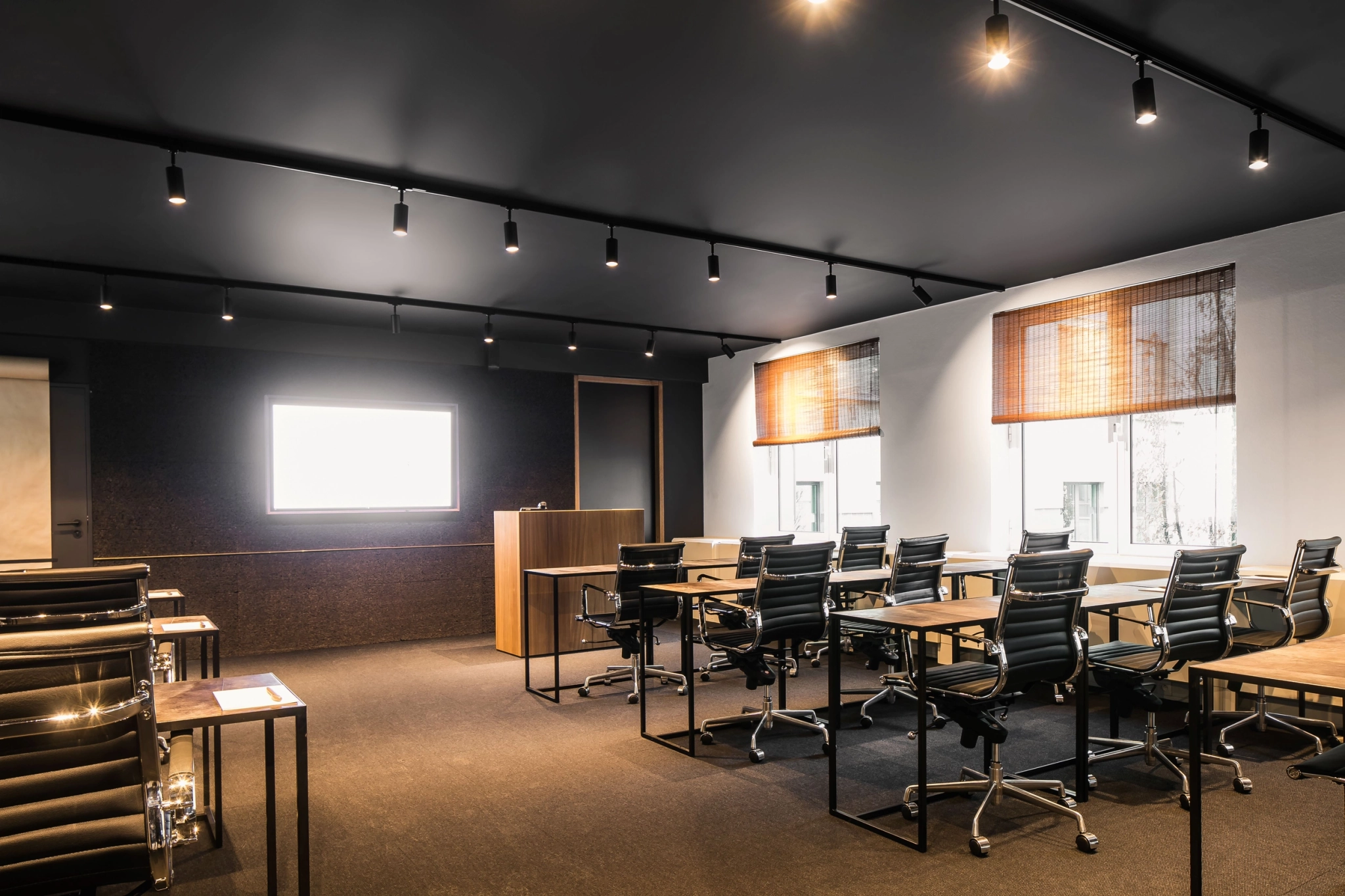 A meeting room in Brussels with black walls and black chairs.
