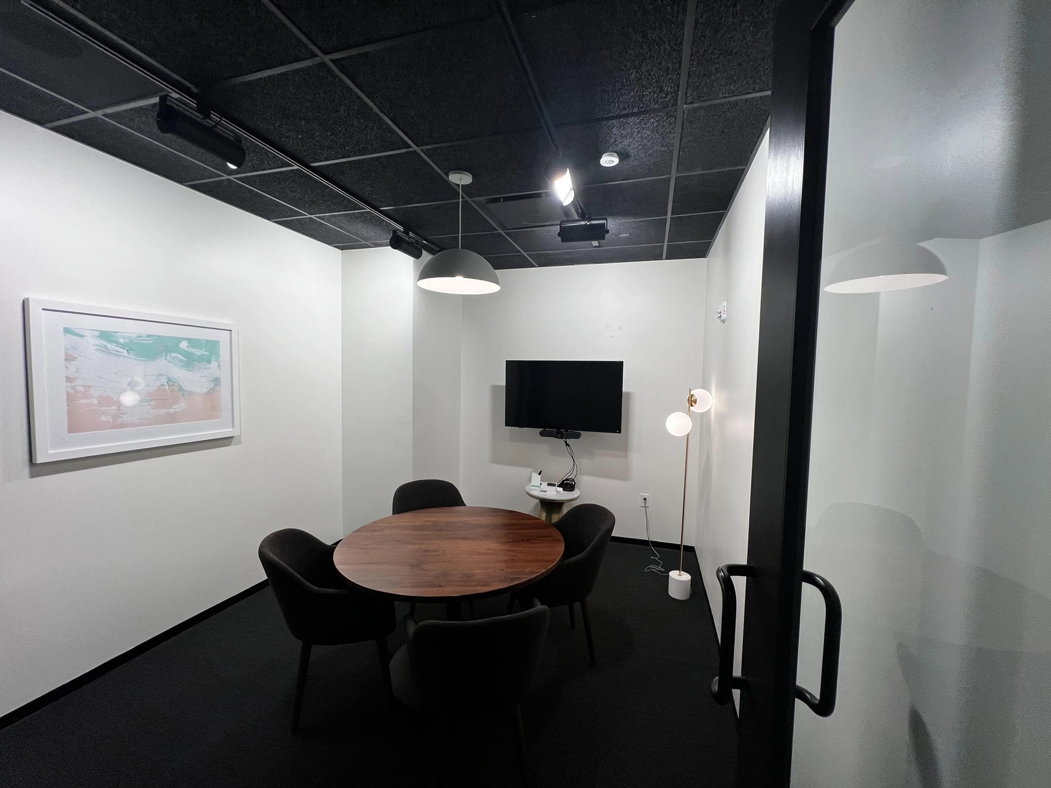 A coworking meeting room equipped with a table and chairs.