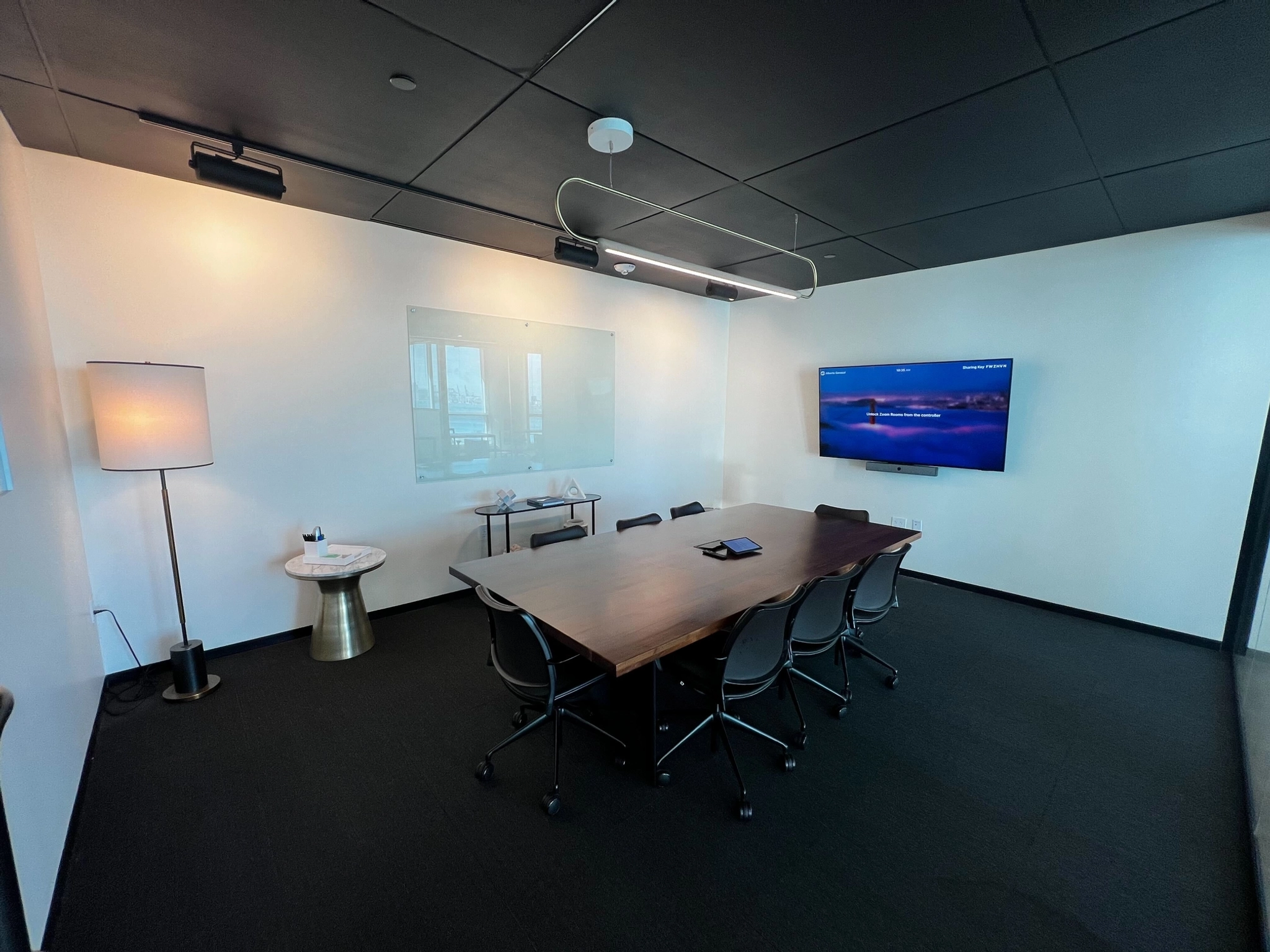 A conference room with a black table and chairs, perfect for office meetings.