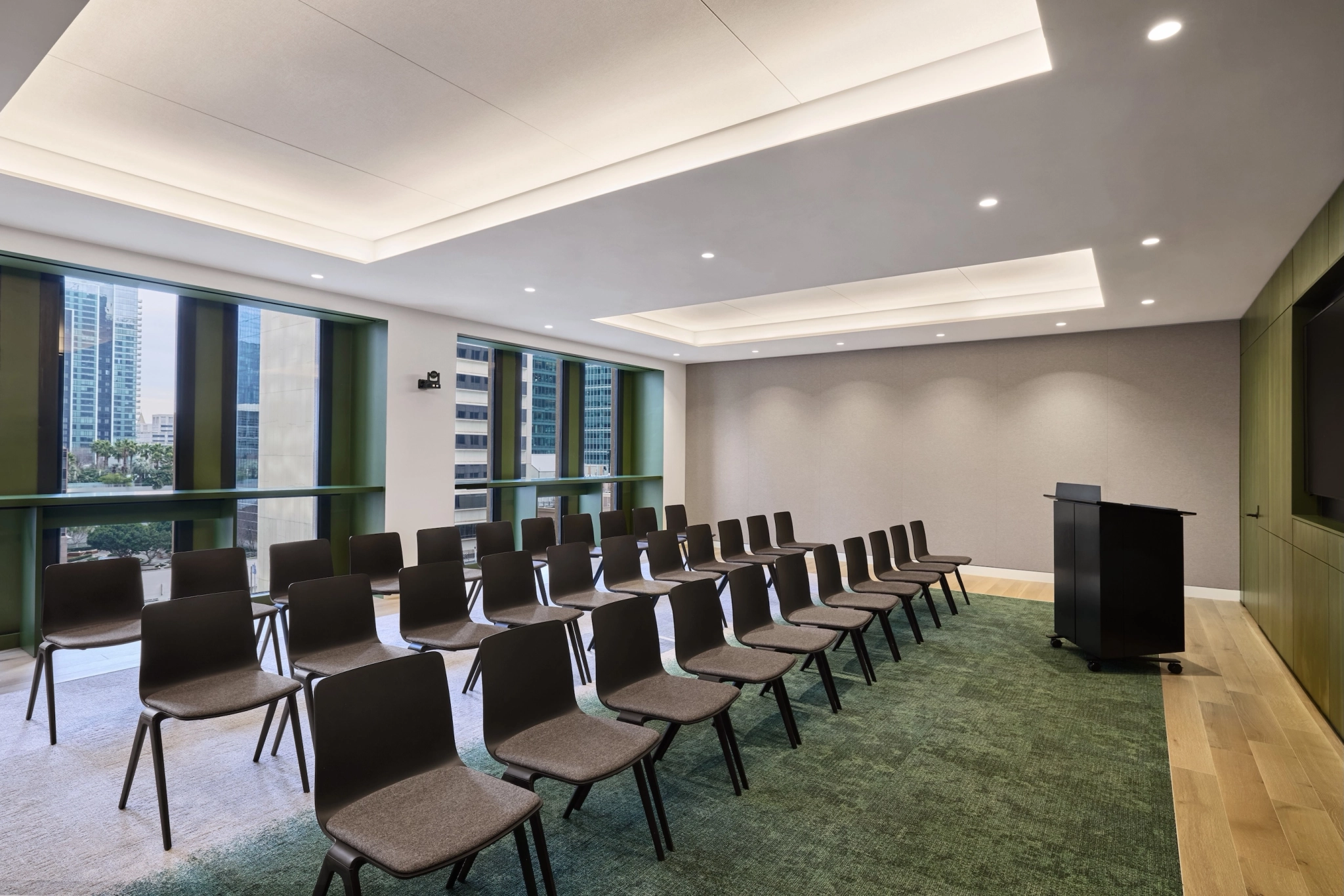 Une salle de conférence vide constitue un espace de travail idéal, avec des rangées de chaises marron faisant face à un podium. Les grandes fenêtres offrent une vue imprenable sur le paysage urbain de San Francisco, créant ainsi une toile de fond inspirante pour les réunions et les présentations.