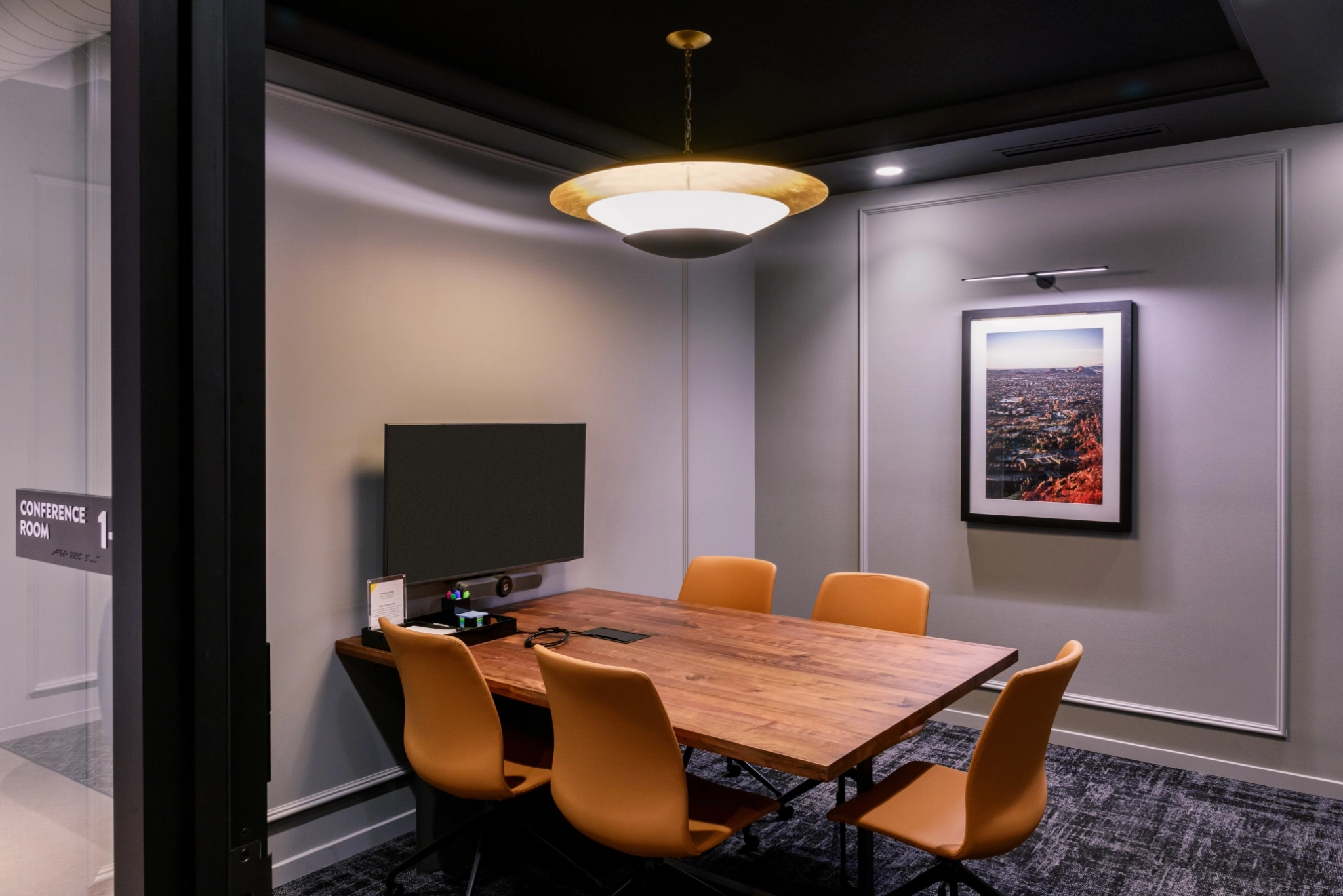 una sala de reuniones grande y luminosa con una pantalla grande