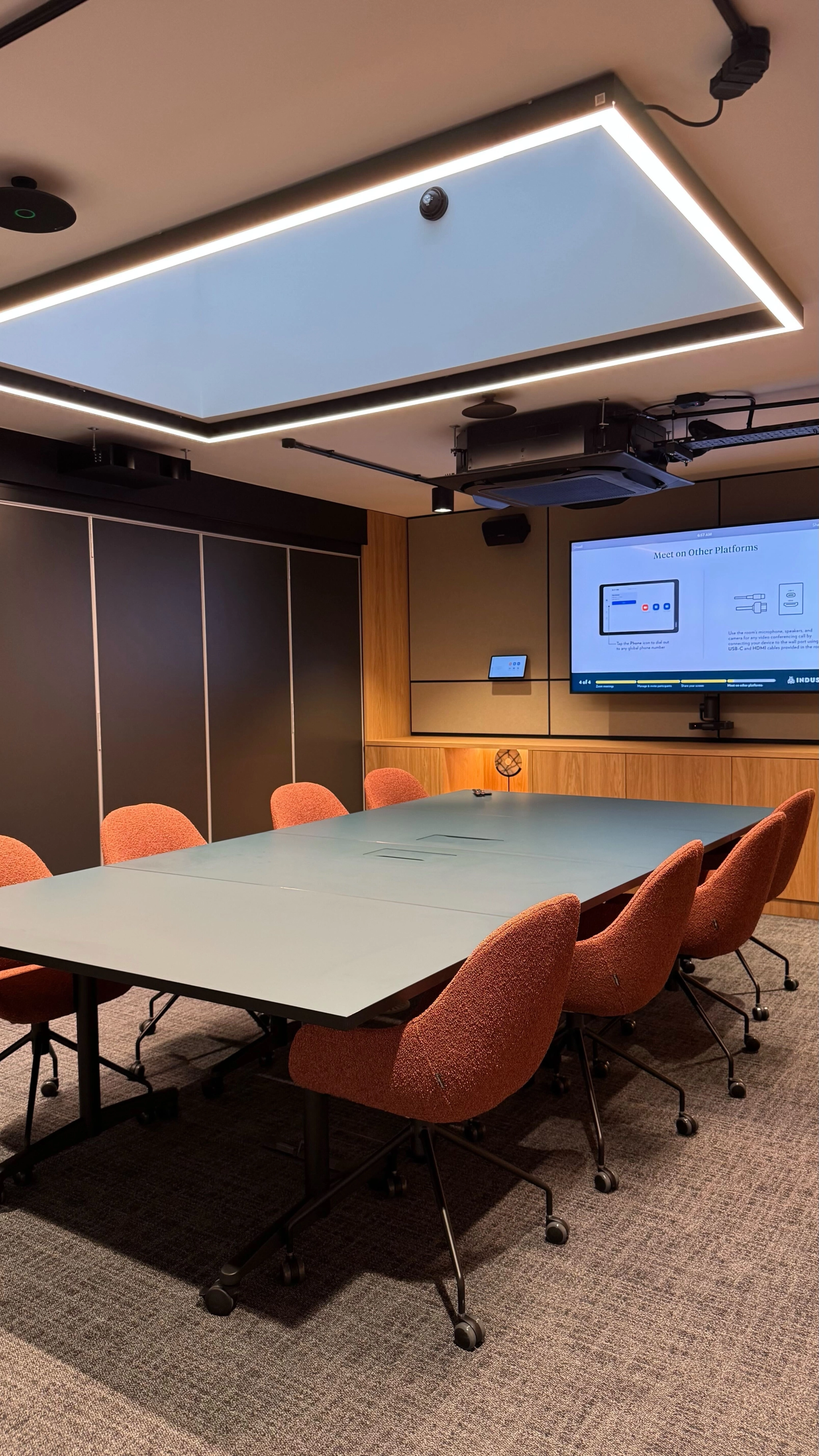 une grande salle de réunion lumineuse avec un grand écran