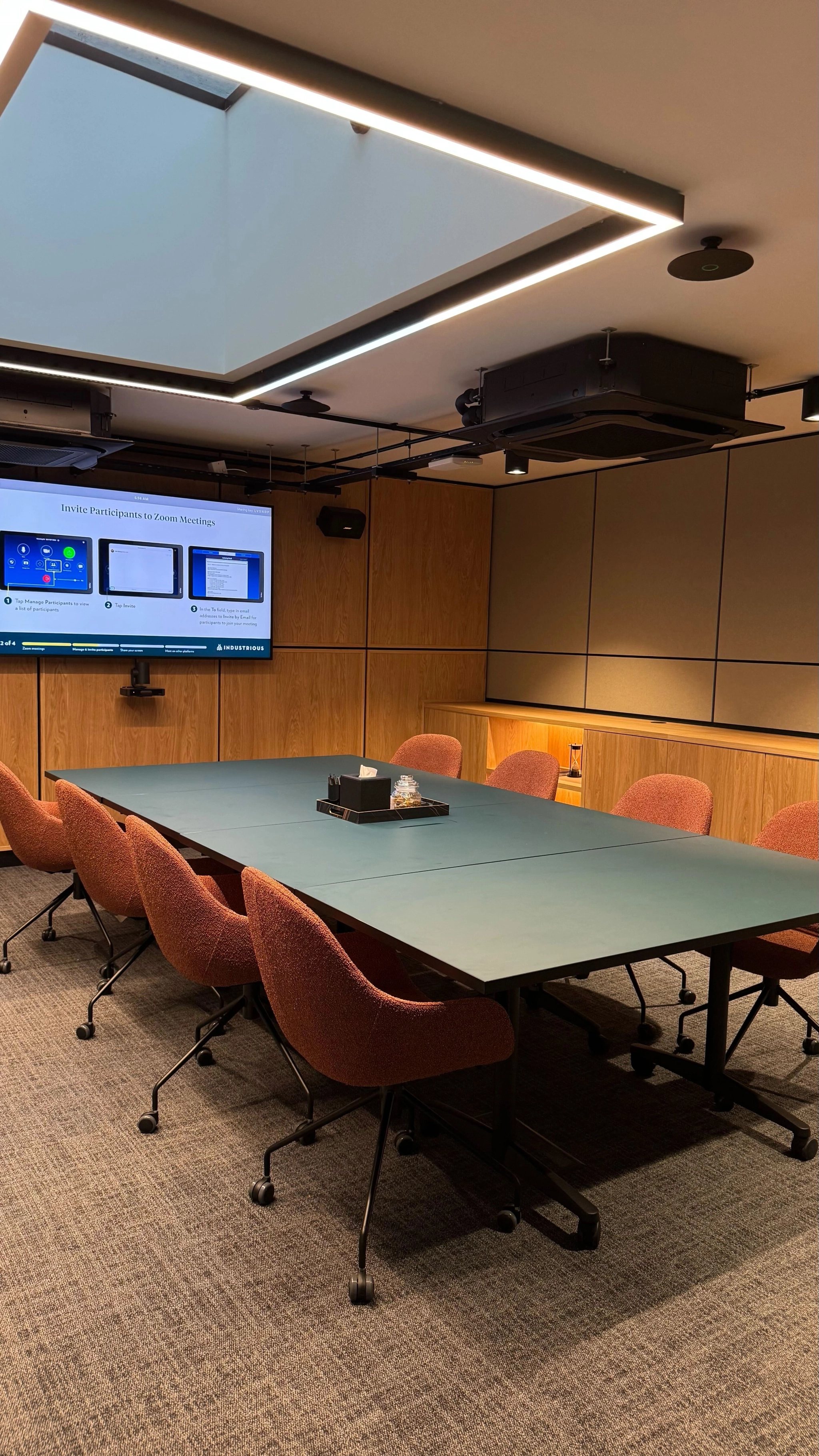 una sala de reuniones grande y luminosa con una pantalla grande